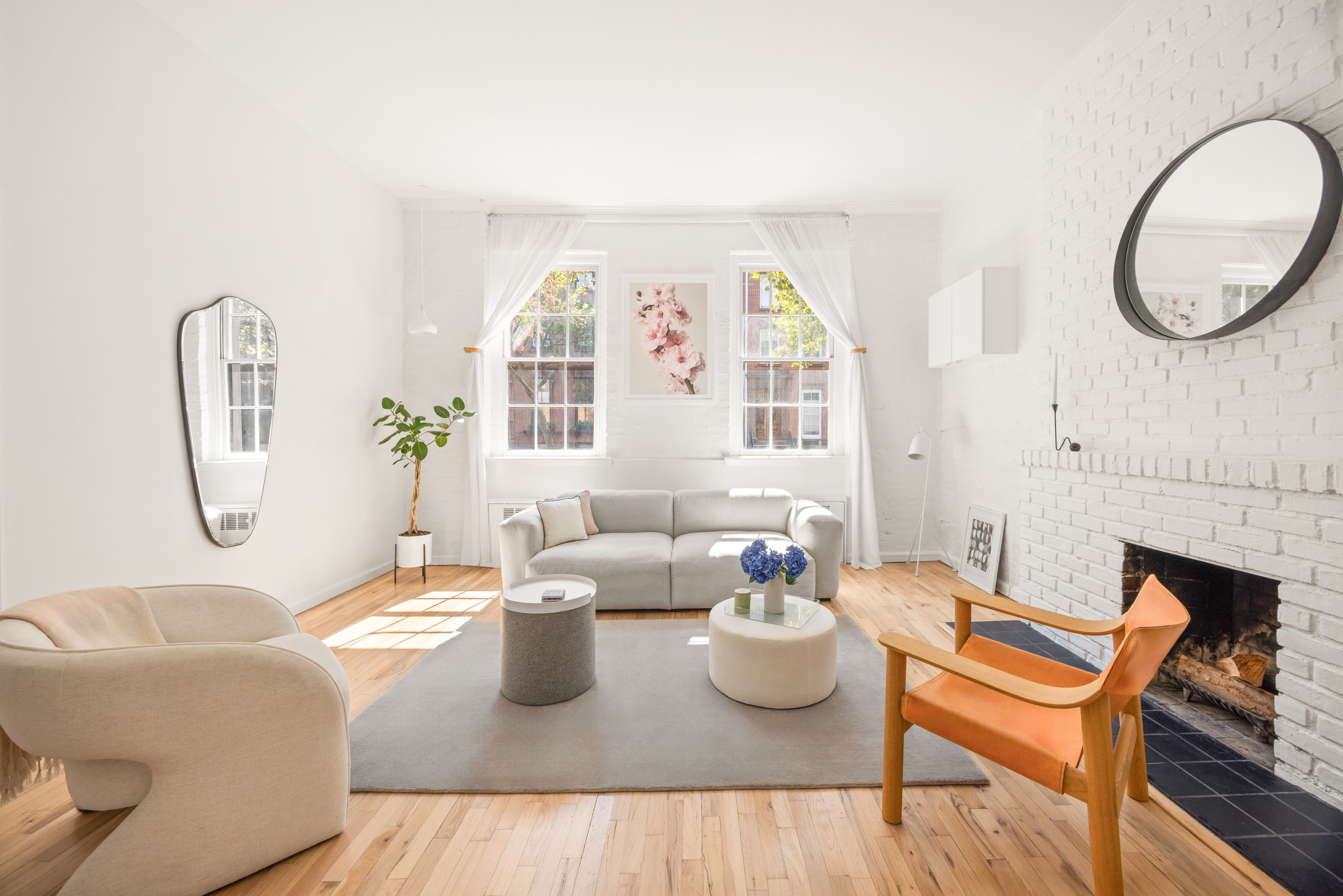 a living room with furniture a table and a large mirror next to a window