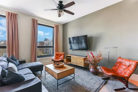 a living room with furniture a rug and a flat screen tv