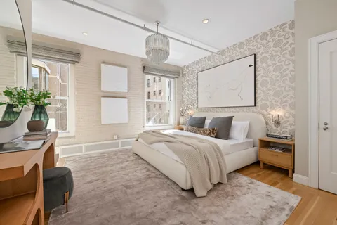 a spacious bedroom with a bed a bookshelf and a window