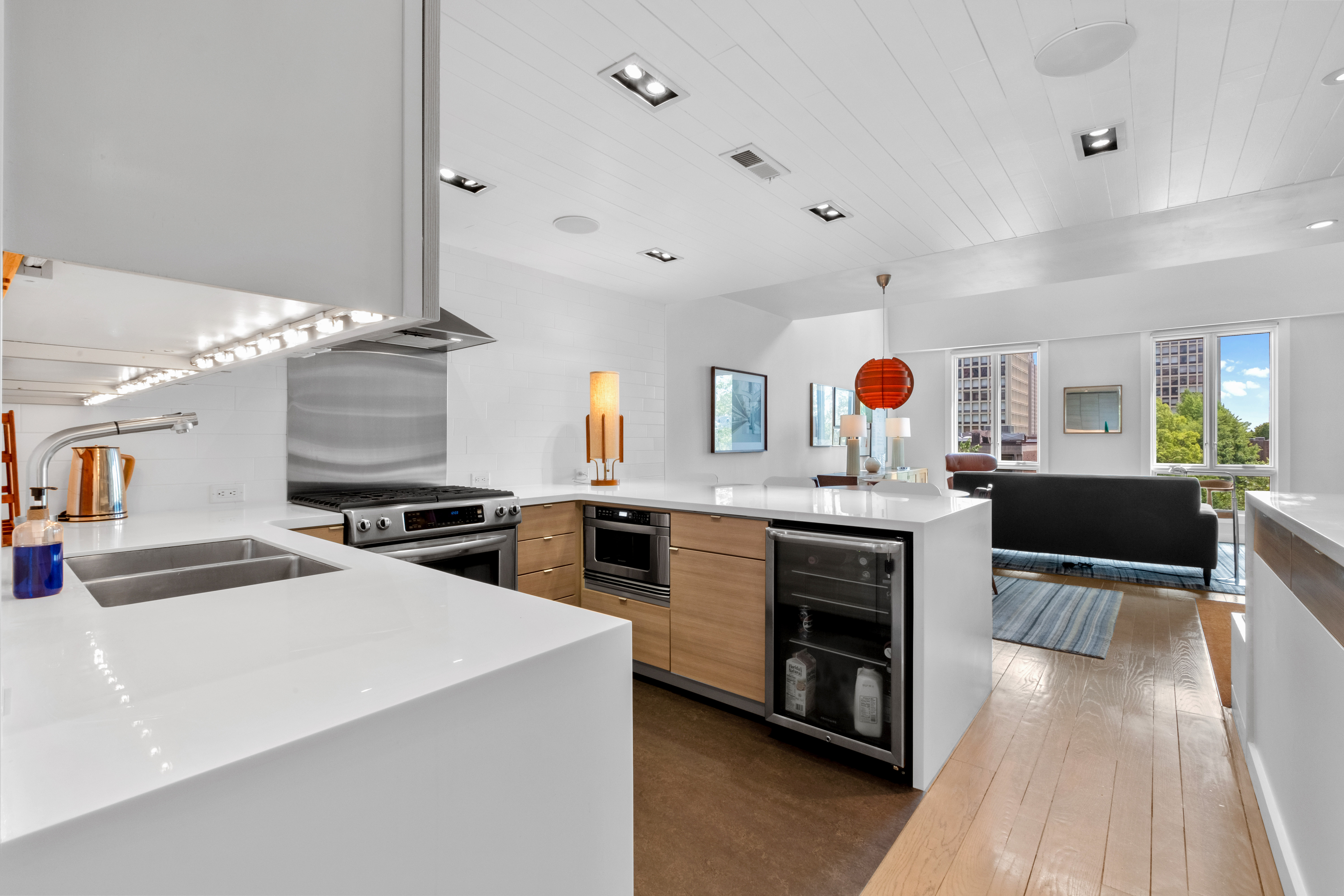 256 1/2 South 3rd Street Philadelphia, PA 19106 - Photo 19 of 73 a large kitchen with stainless steel appliances a stove a sink dishwasher and a fireplace with wooden floor