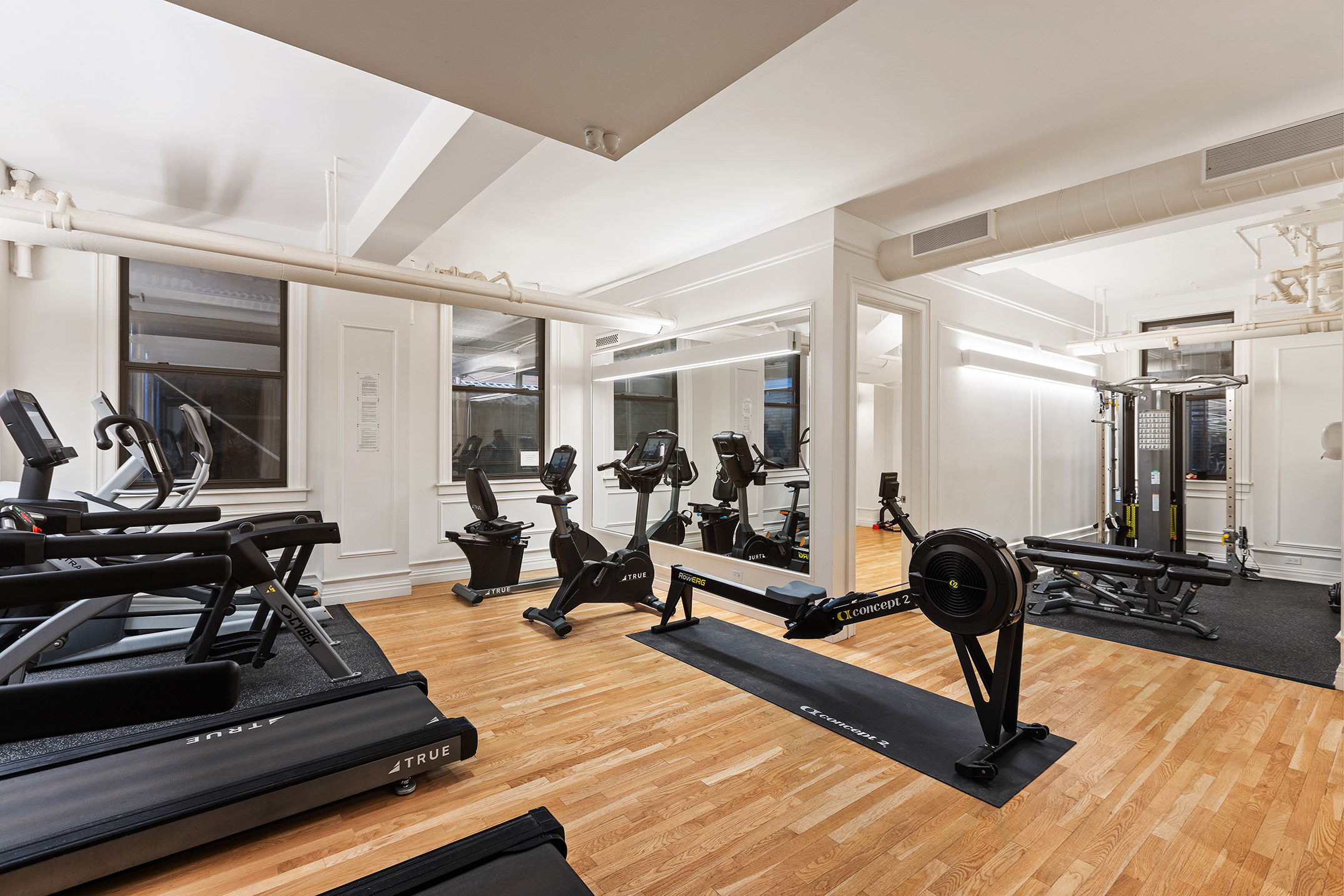 395 Riverside Drive, Unit 7F Manhattan, NY 10025 - Photo 8 of 10 a living room with wooden floor and gym equipment