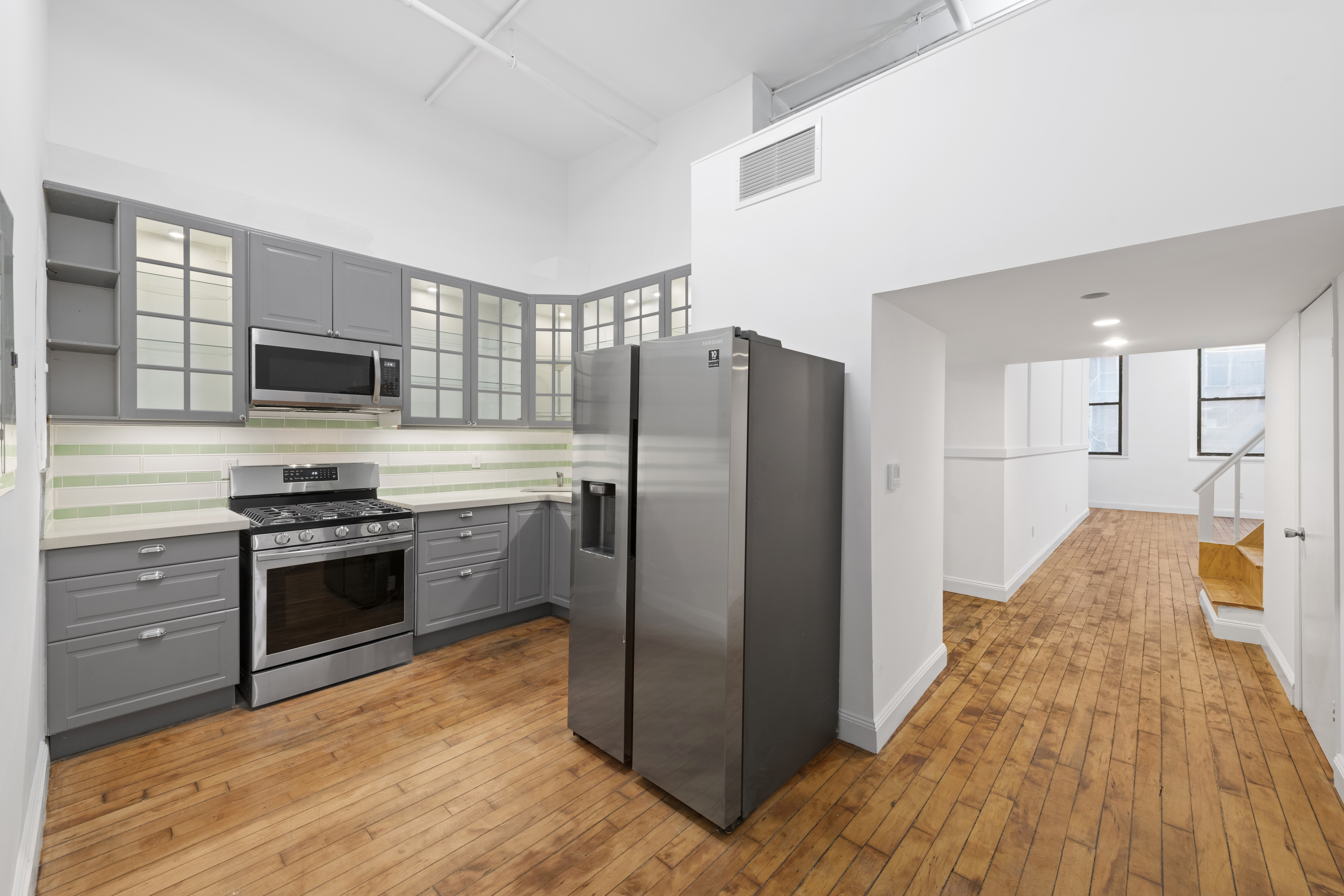 49 Walker Street, Unit 2B Manhattan, NY 10013 - Photo 1 of 7 a kitchen with stainless steel appliances granite countertop a refrigerator stove and oven