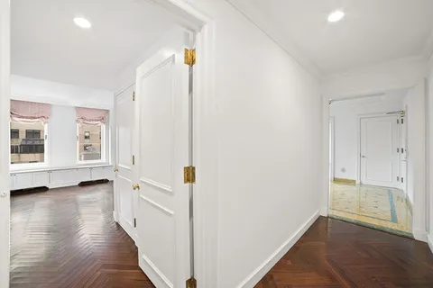a view of empty room with wooden floor and window