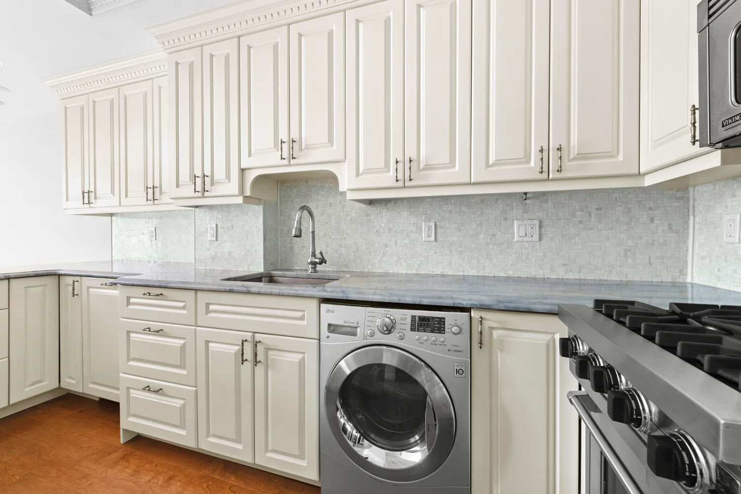 a kitchen with white cabinets and a stove top oven