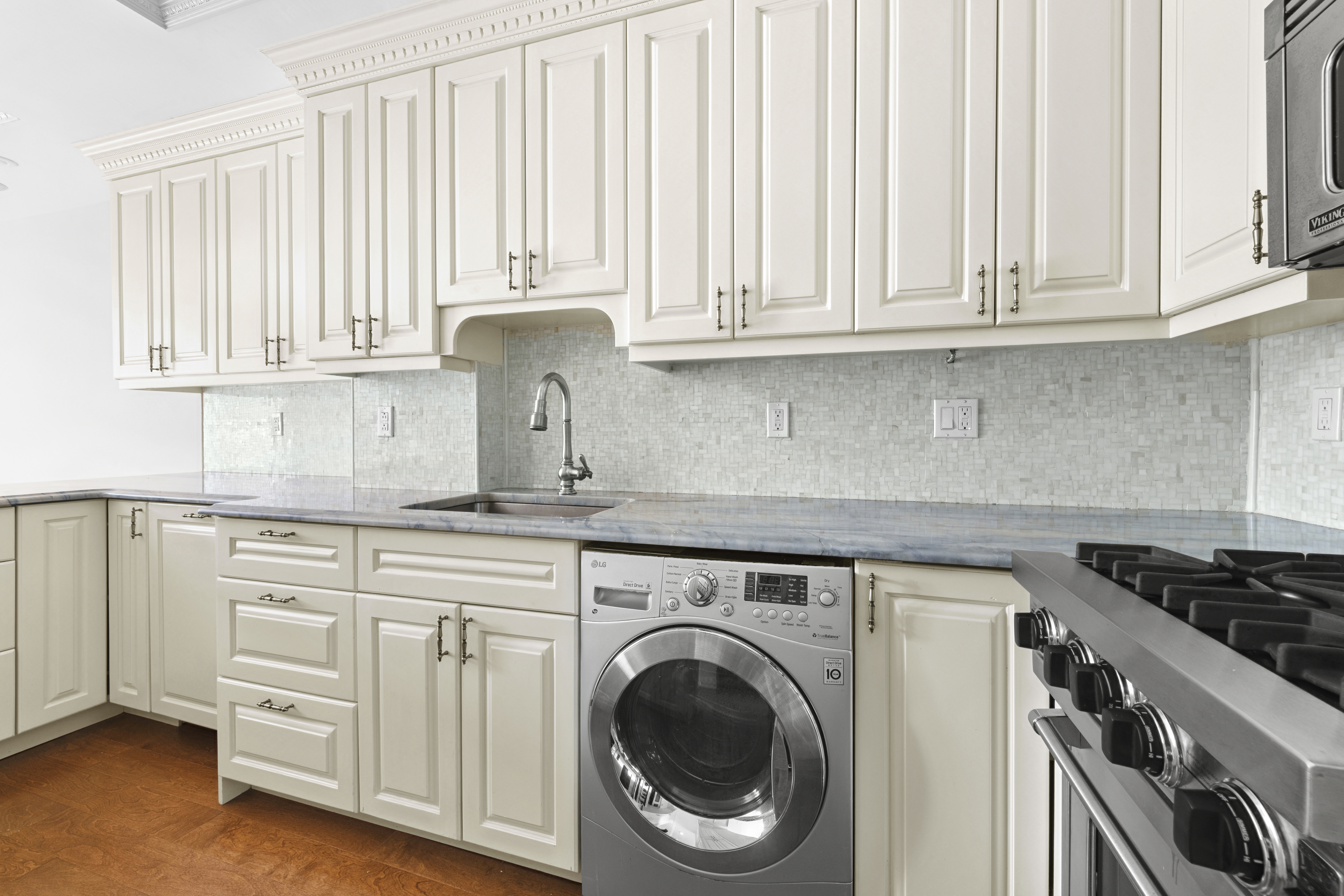393 West 49th Street, Unit 5NN Manhattan, NY 10019 - Photo 6 of 13 a kitchen with white cabinets and a stove top oven