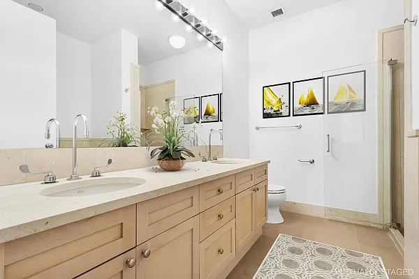252 7th Avenue, Unit 10I Manhattan, NY 10001 - Photo 7 of 25 a bathroom with a double vanity sink mirror and toilet