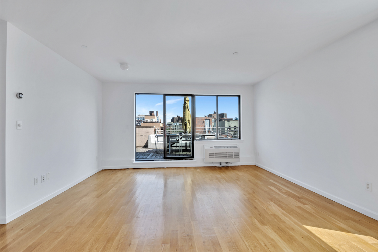 416 East 117th Street, Unit PH6 Manhattan, NY 10035 - Photo 13 of 18 a big room with wooden floor and natural light