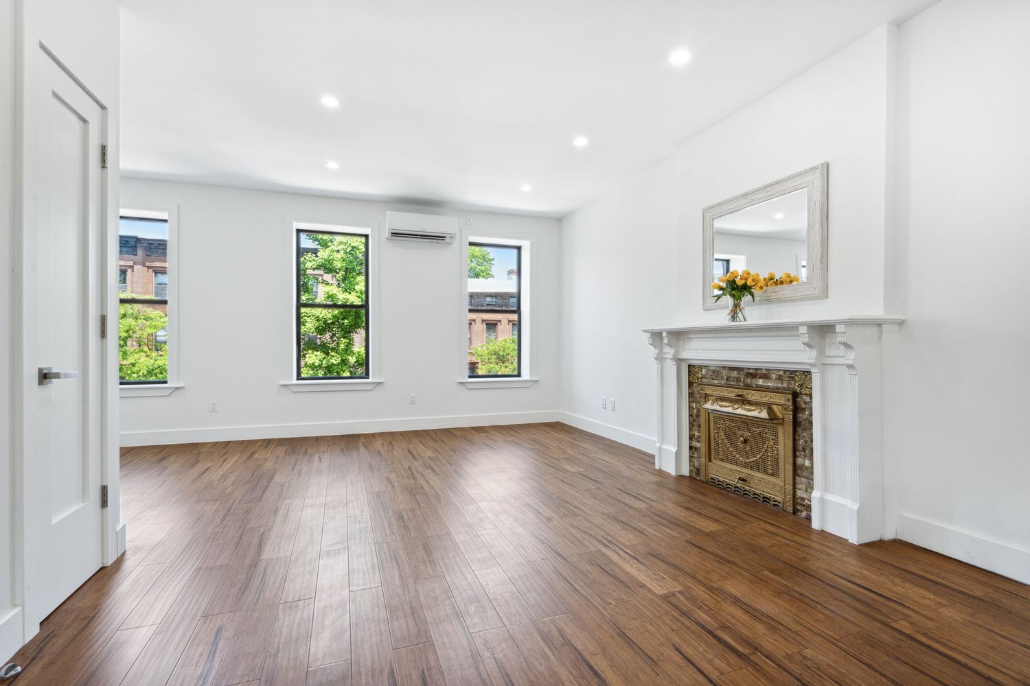692 Putnam Avenue, Unit 2 Brooklyn, NY 11221 - Photo 2 of 15 an empty room with windows and fireplace