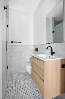 a bathroom with a sink a toilet and shower