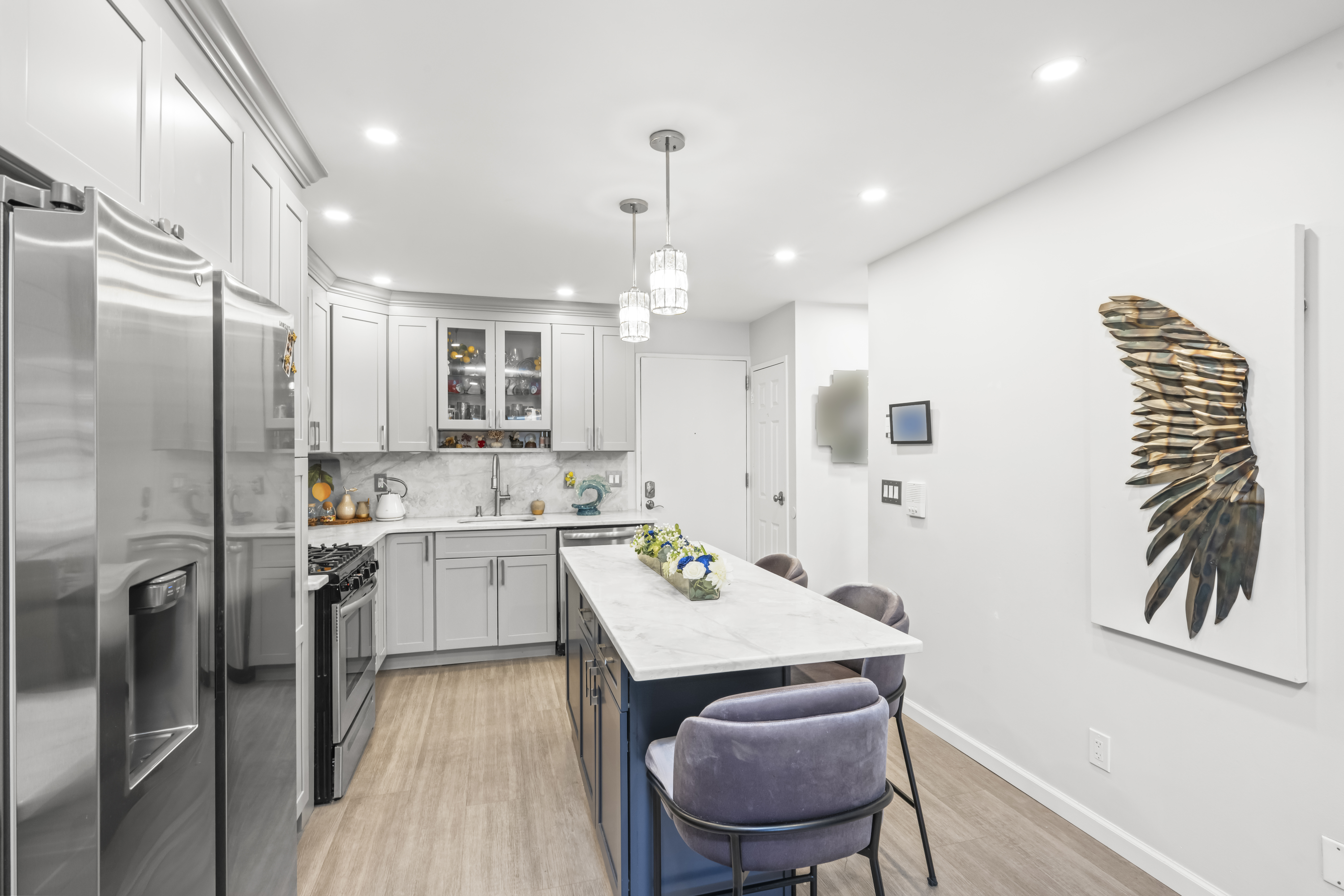 2 Elmwood Park Drive, Unit 209 Staten Island, NY 10314 - Photo 8 of 17 a kitchen with a refrigerator a sink dishwasher a stove and a dining table with wooden floor