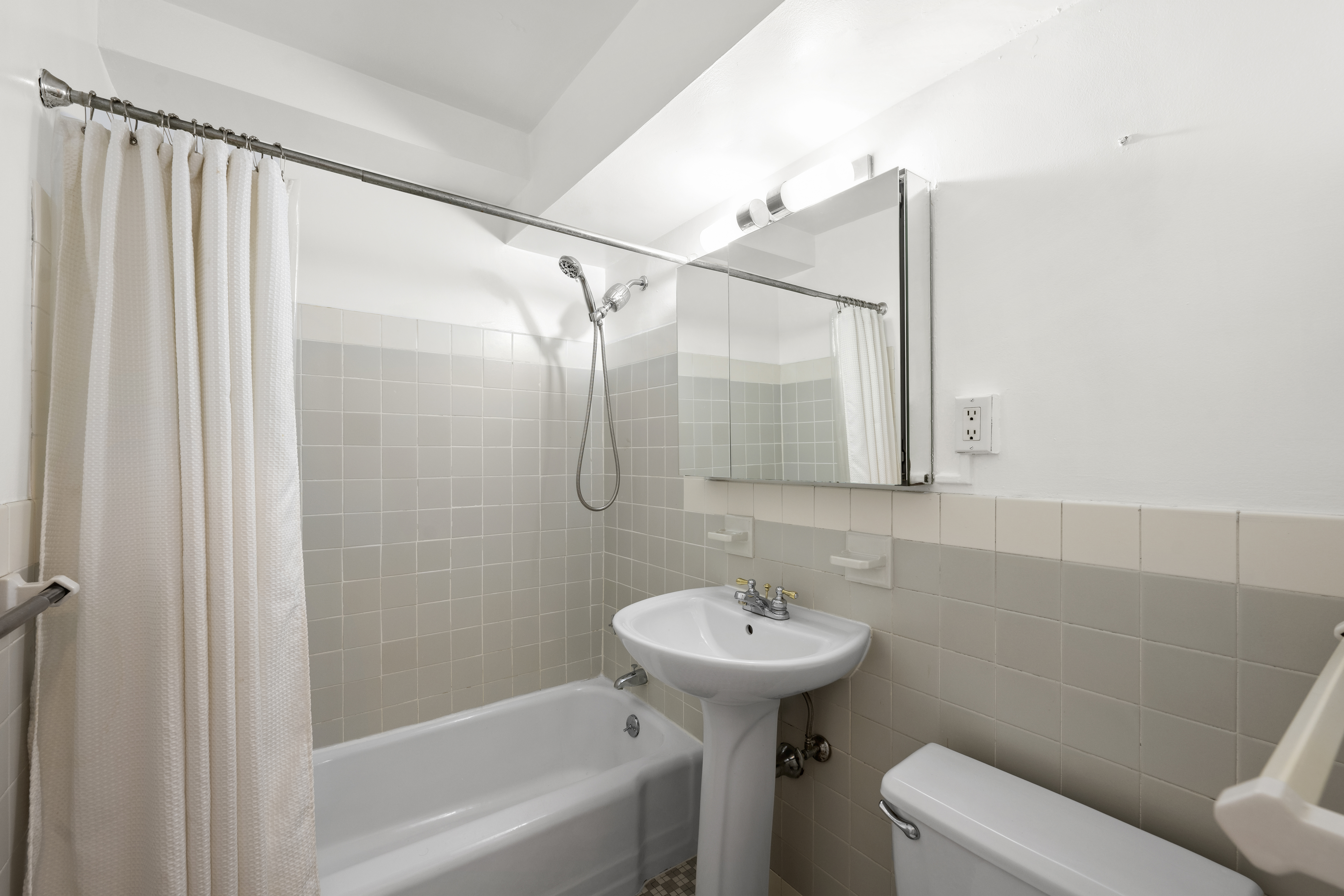 303 West 66th Street, Unit 2AE Manhattan, NY 10023 - Photo 9 of 15 a bathroom with a sink toilet and shower