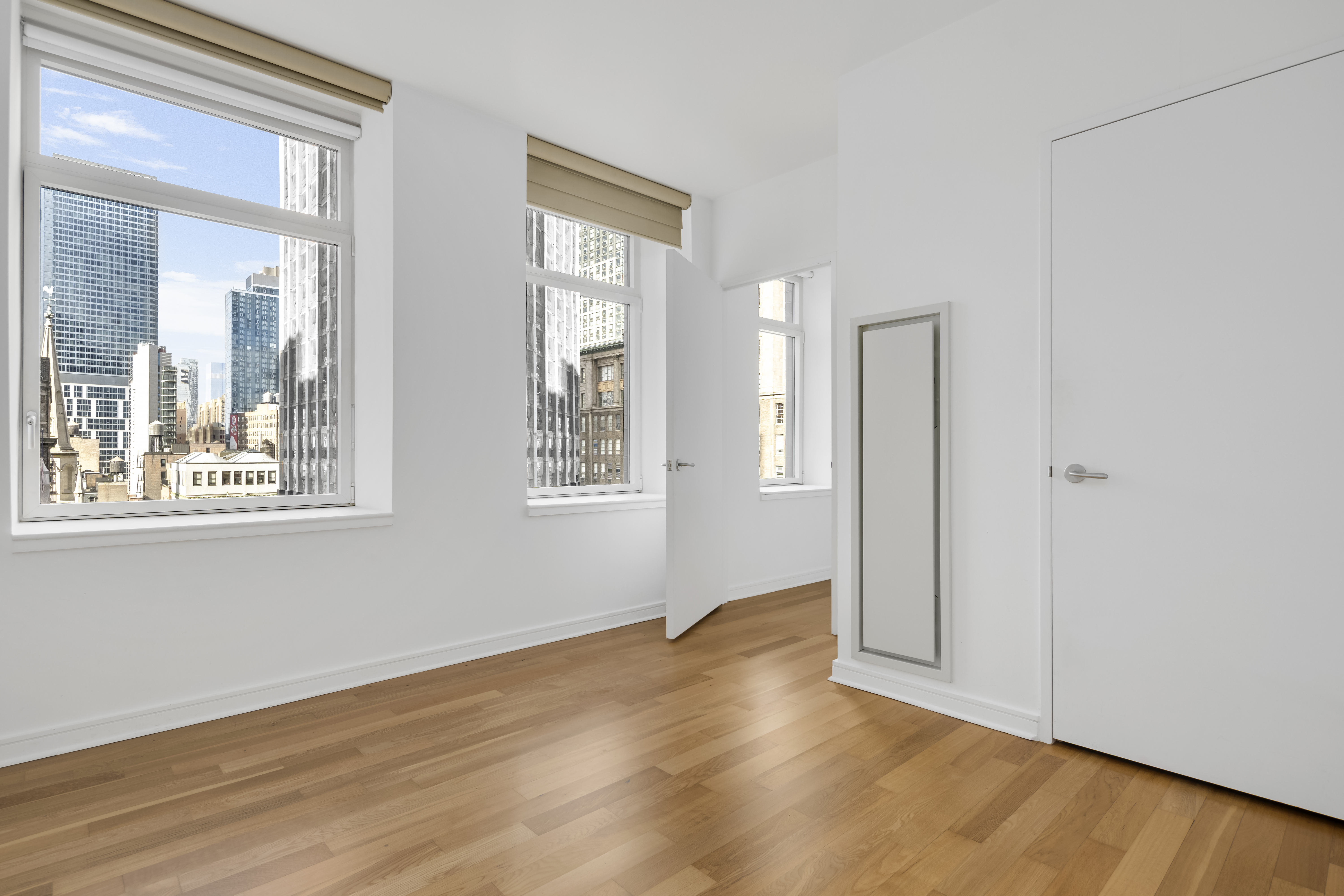 11 East 29th Street, Unit 15B Manhattan, NY 10016 - Photo 5 of 8 an empty room with wooden floor and windows