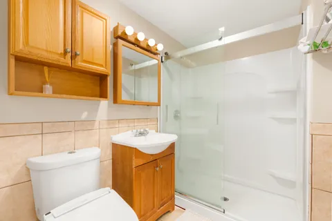 a bathroom with a sink a toilet and shower