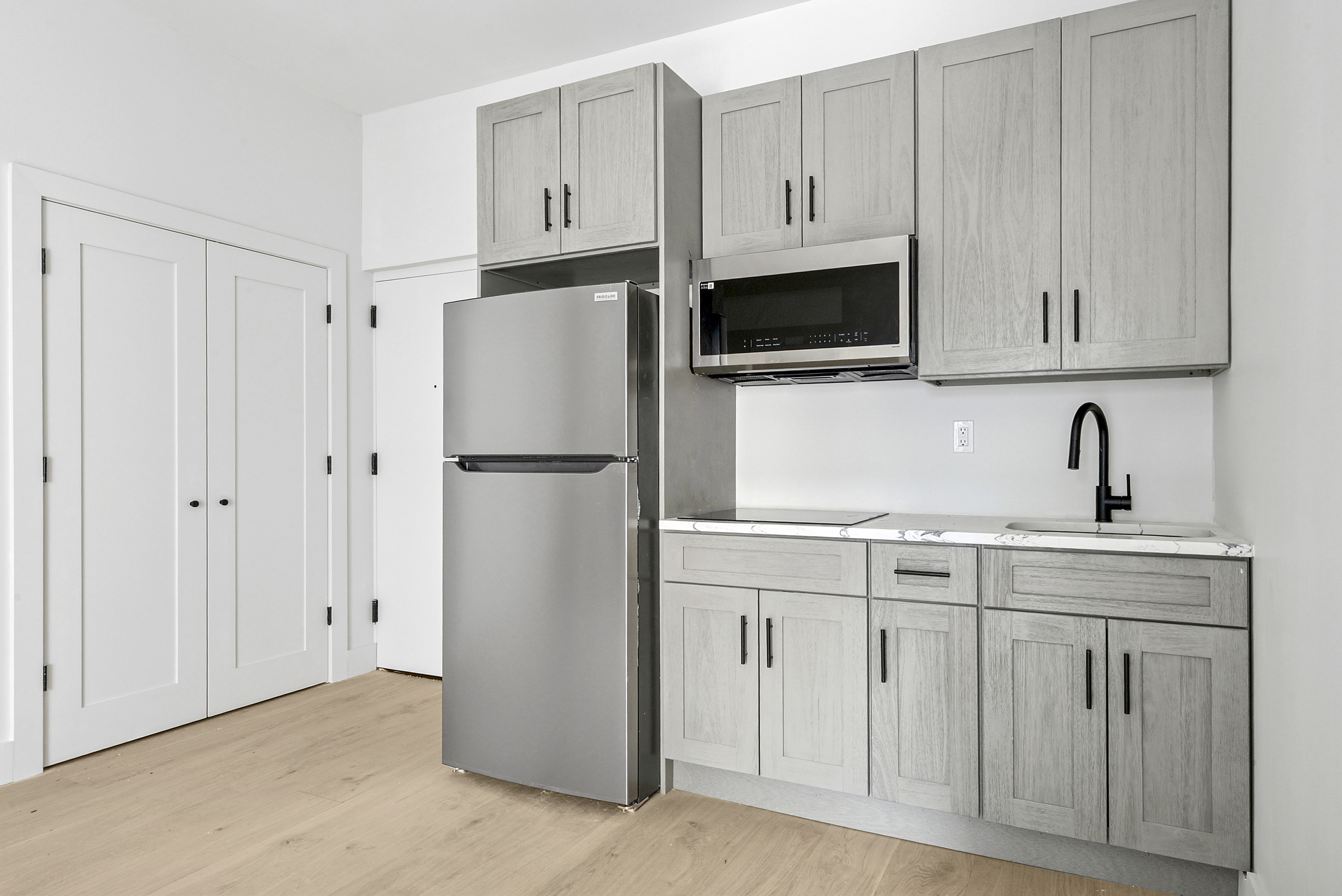 20 East 66th Street, Unit 5B Manhattan, NY 10065 - Photo 4 of 9 a kitchen with white cabinets and refrigerator