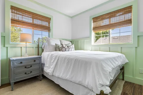 a bed sitting in a bedroom next to a window