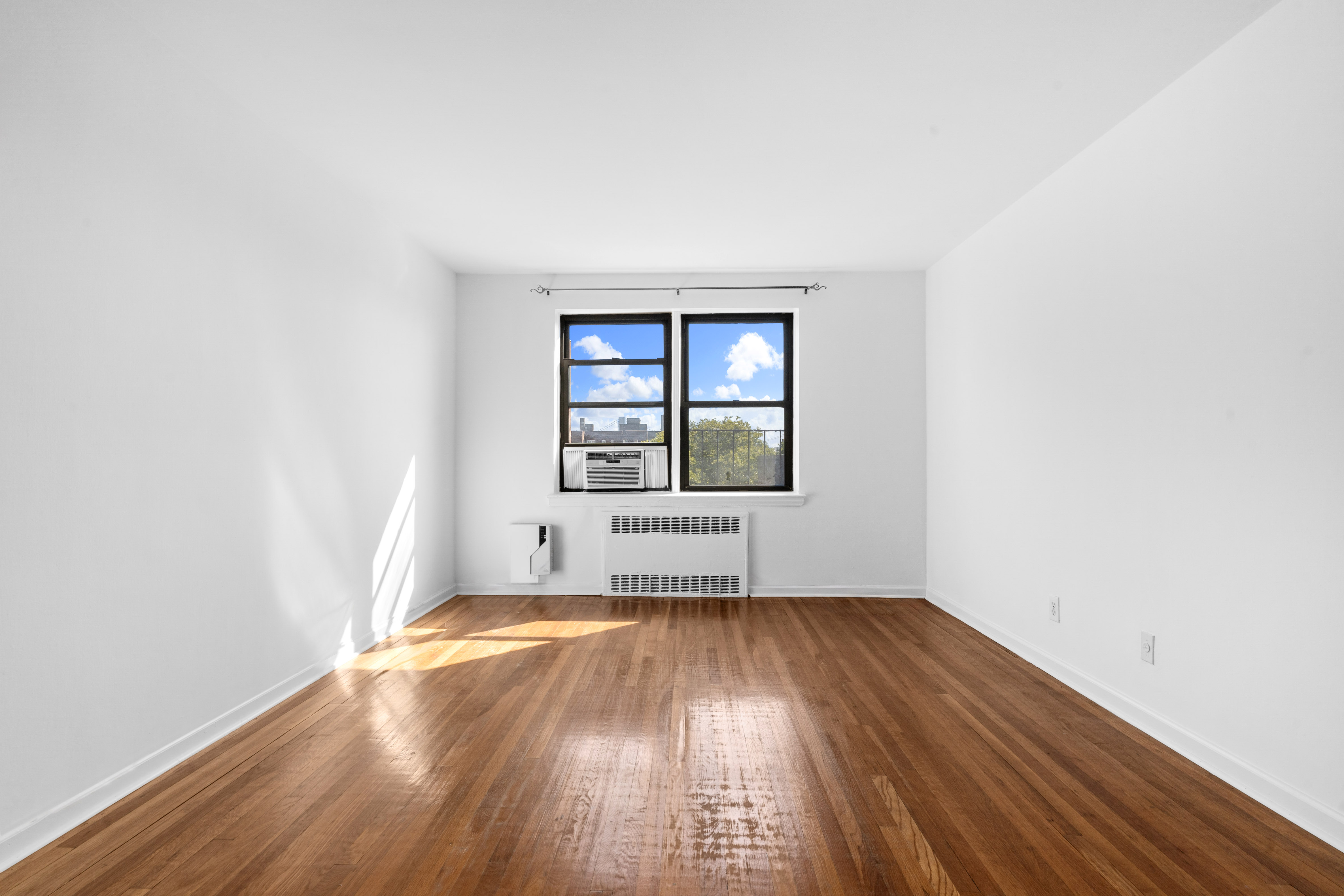 145 72nd Street, Unit F7 Brooklyn, NY 11209 - Photo 2 of 9 an empty room with wooden floor and windows