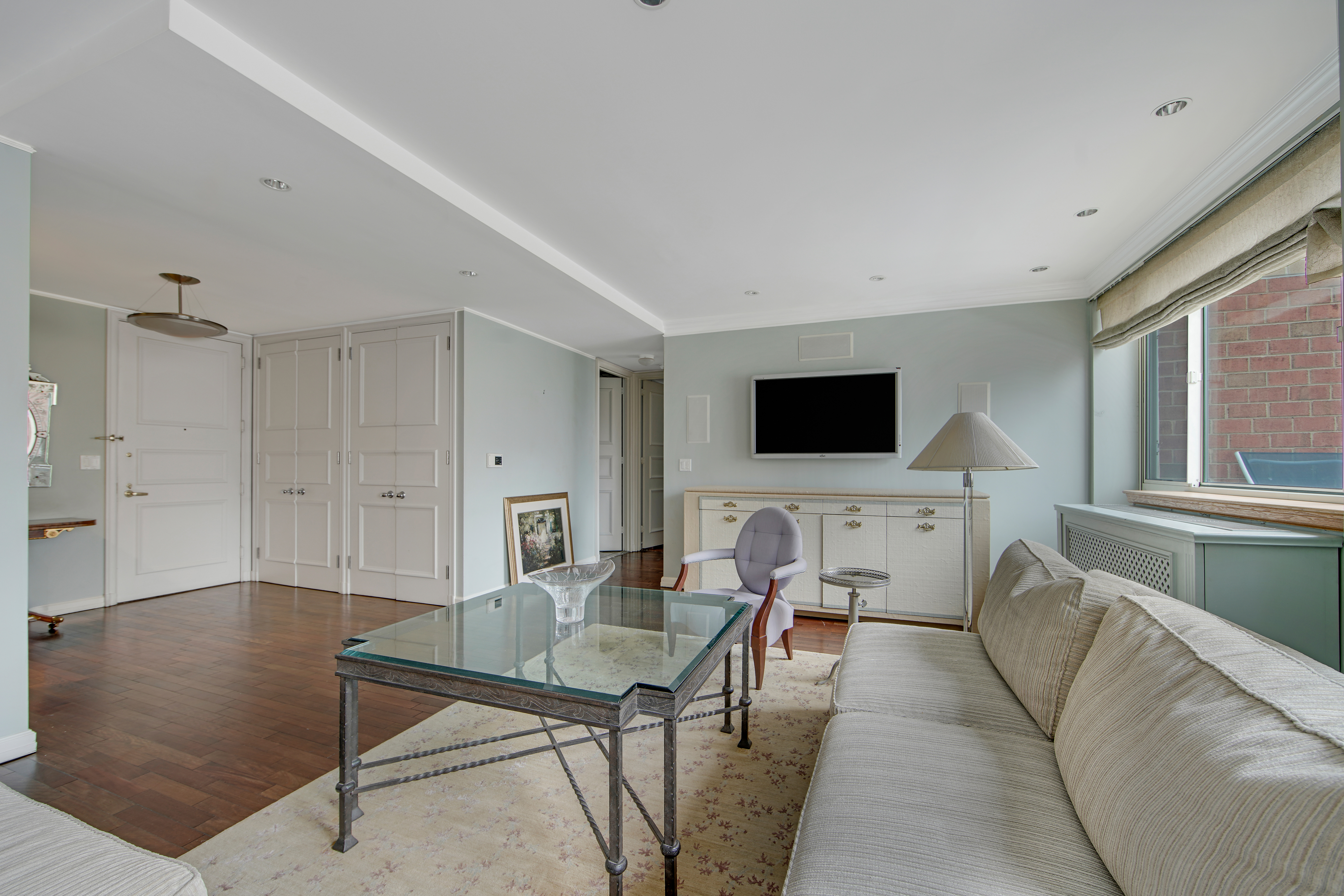 201 East 80th Street, Unit 16D Manhattan, NY 10075 - Photo 2 of 19 a living room with furniture and a flat screen tv