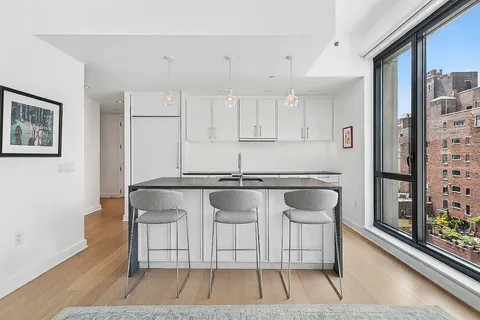 a kitchen with stainless steel appliances granite countertop a stove a sink and a refrigerator with white cabinets