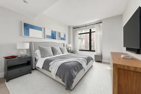 a bedroom with a bed and a flat screen tv