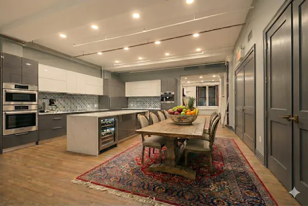 a kitchen with a dining table chairs stainless steel appliances and cabinets
