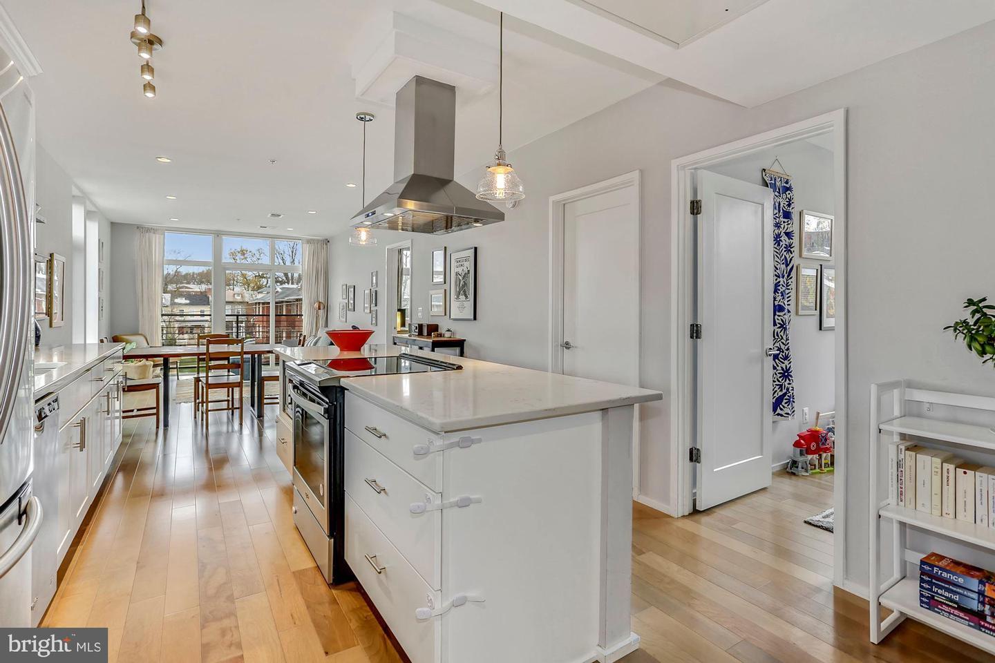 129 Varnum Street Northwest, Unit 6 Washington, DC 20011 - Photo 4 of 25 a kitchen with stainless steel appliances a lot of counter space and wooden floor
