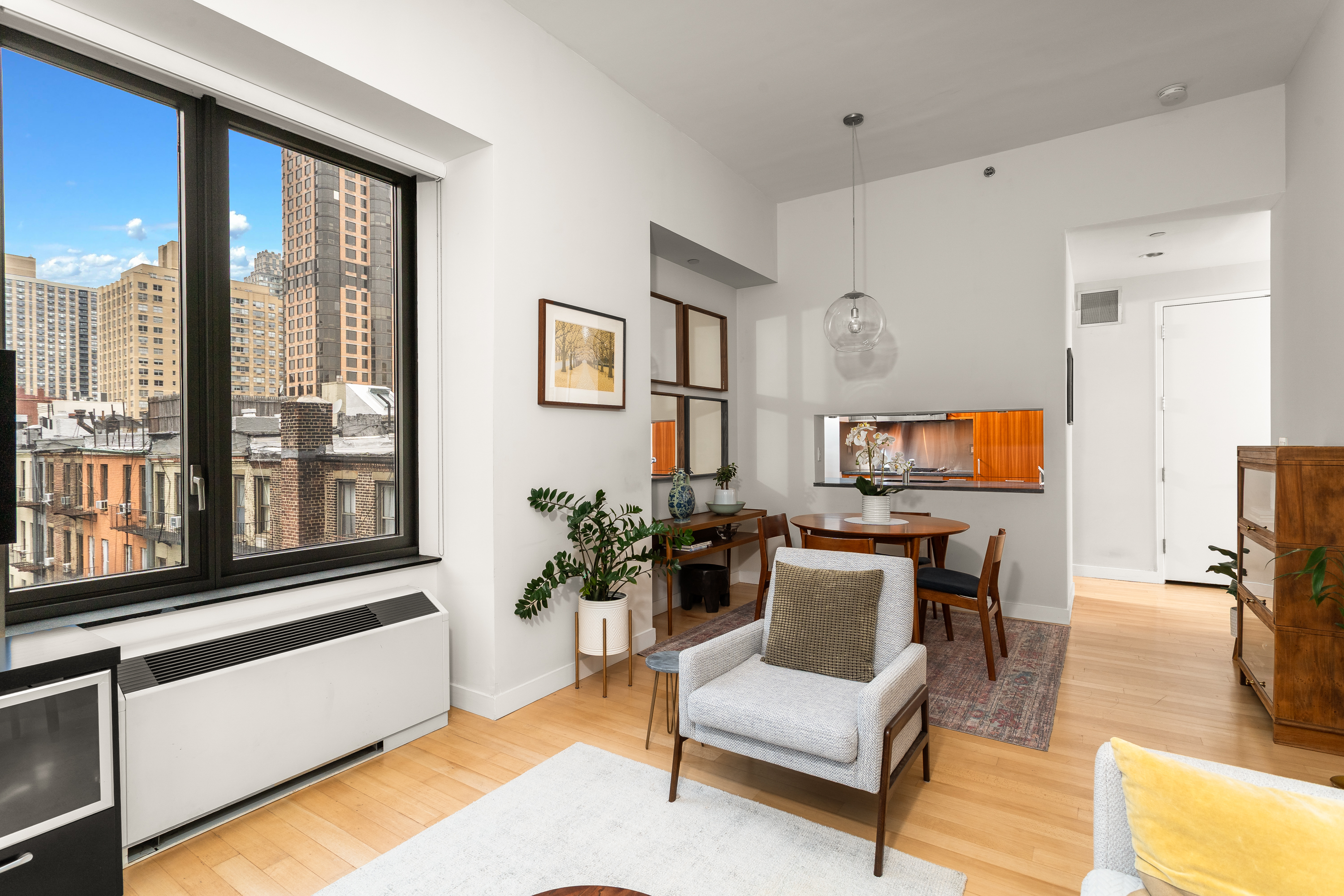 450 East 83rd Street, Unit 5K Manhattan, NY 10028 - Photo 7 of 16 a living room with furniture a flat screen tv and a large window