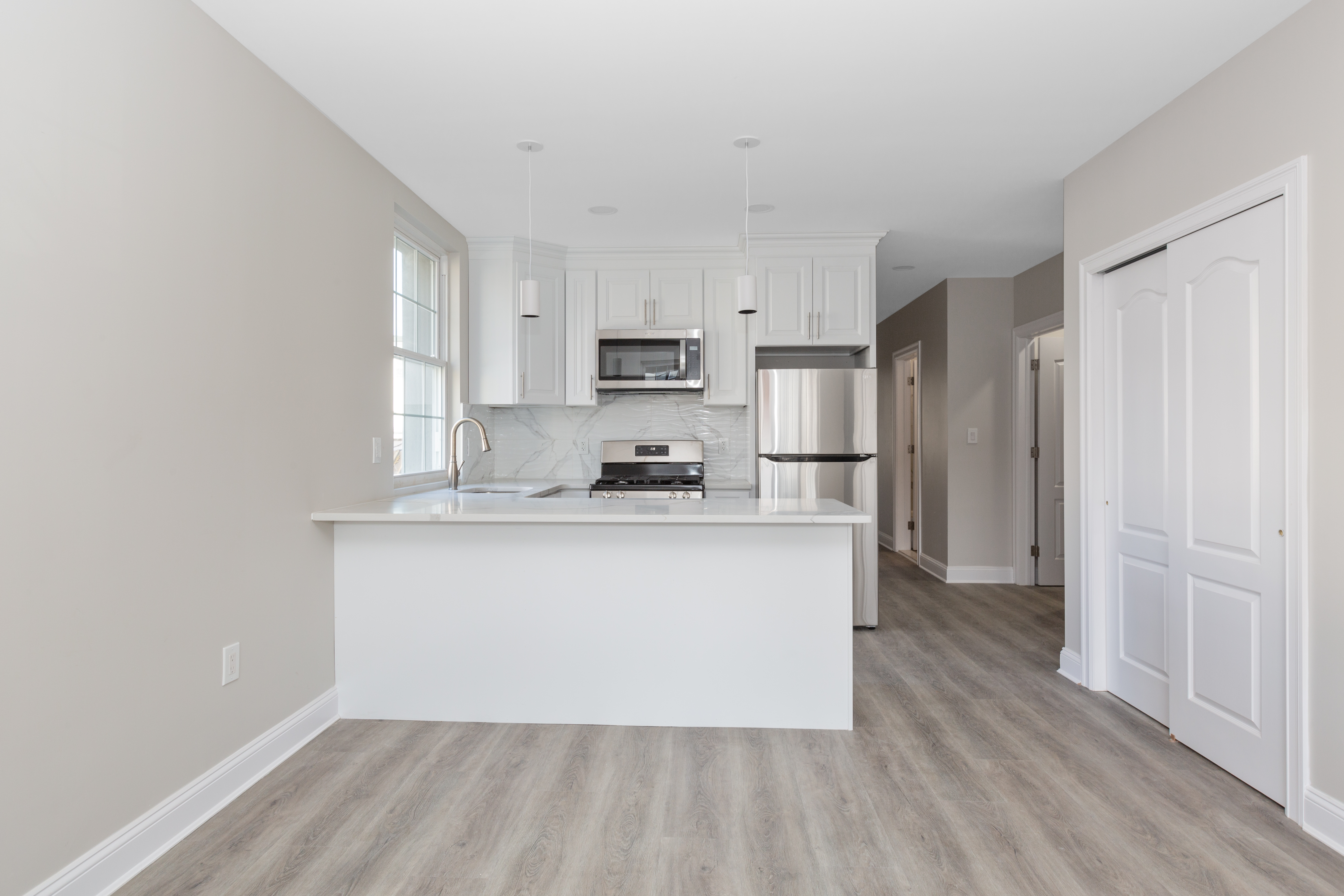 143-10 Shore Avenue Queens, NY 11435 - Photo 18 of 30 a kitchen with stainless steel appliances granite countertop a refrigerator sink and white cabinets