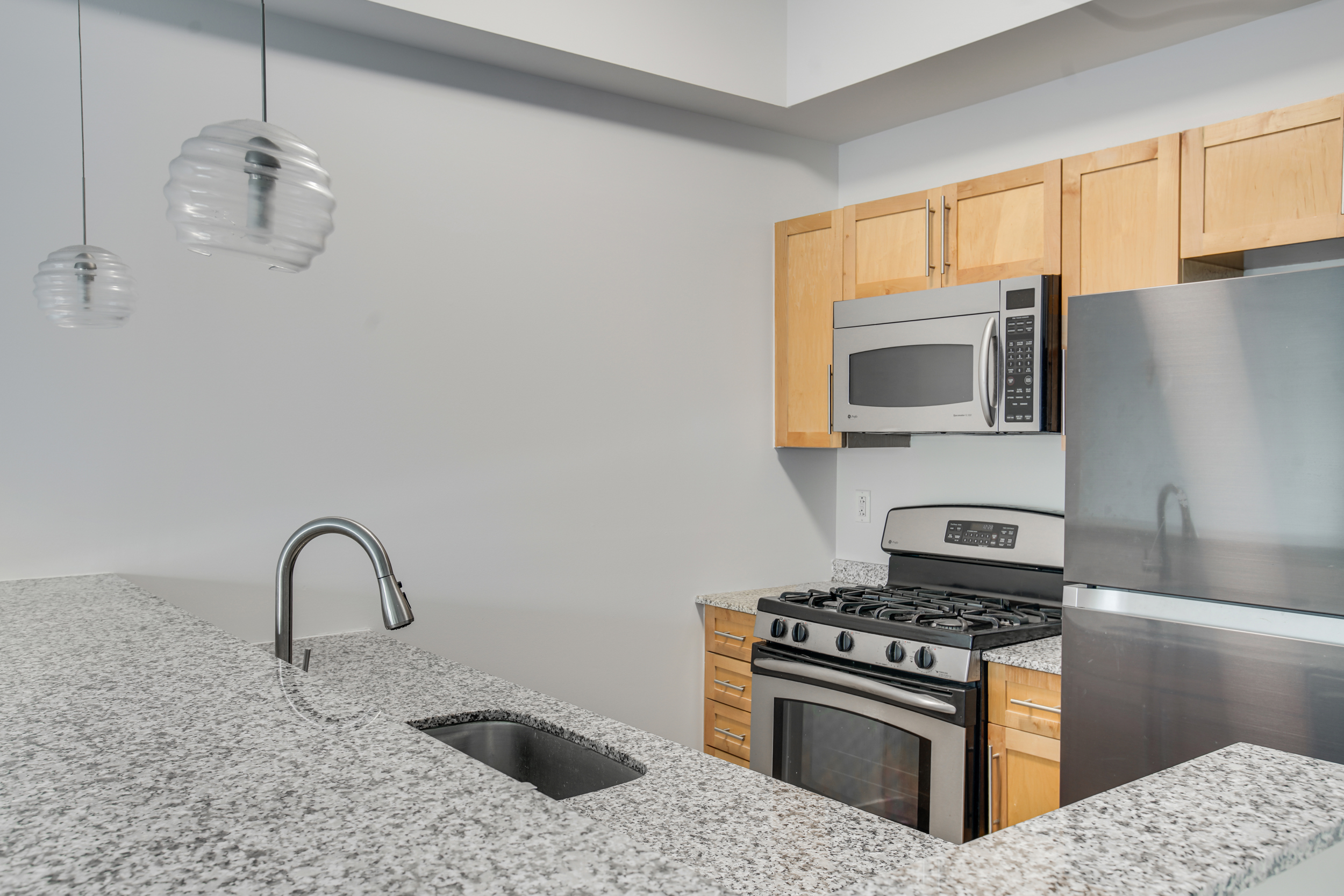 516 West 47th Street, Unit N7A Manhattan, NY 10036 - Photo 4 of 19 a kitchen with stainless steel appliances granite countertop a stove a sink and a microwave