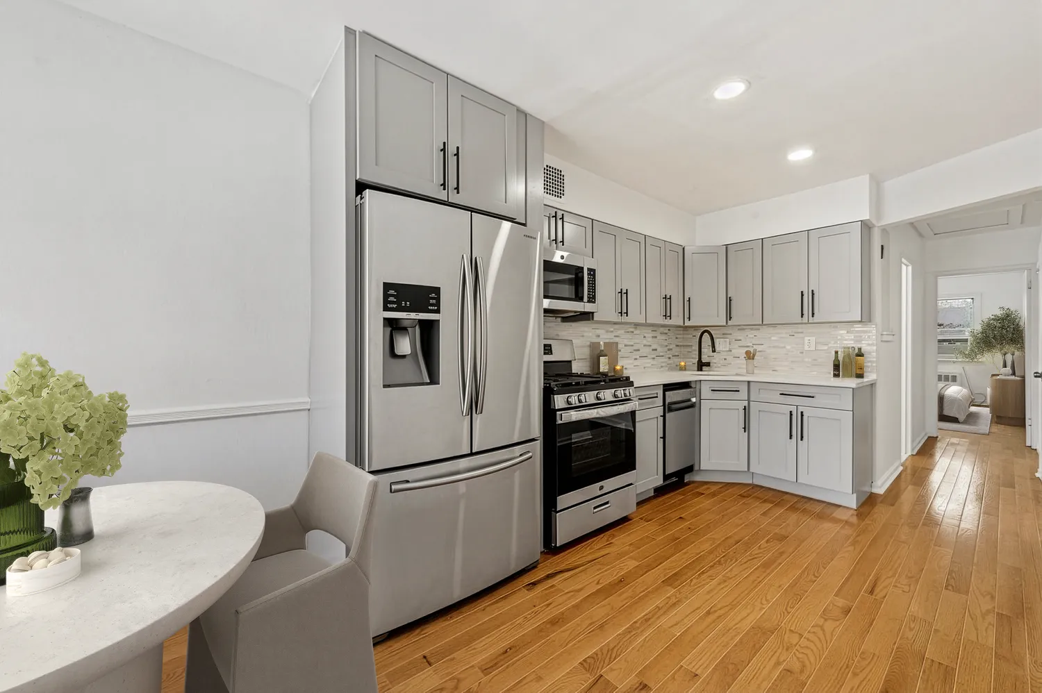 a kitchen with a refrigerator a sink dishwasher and a stove with wooden floor