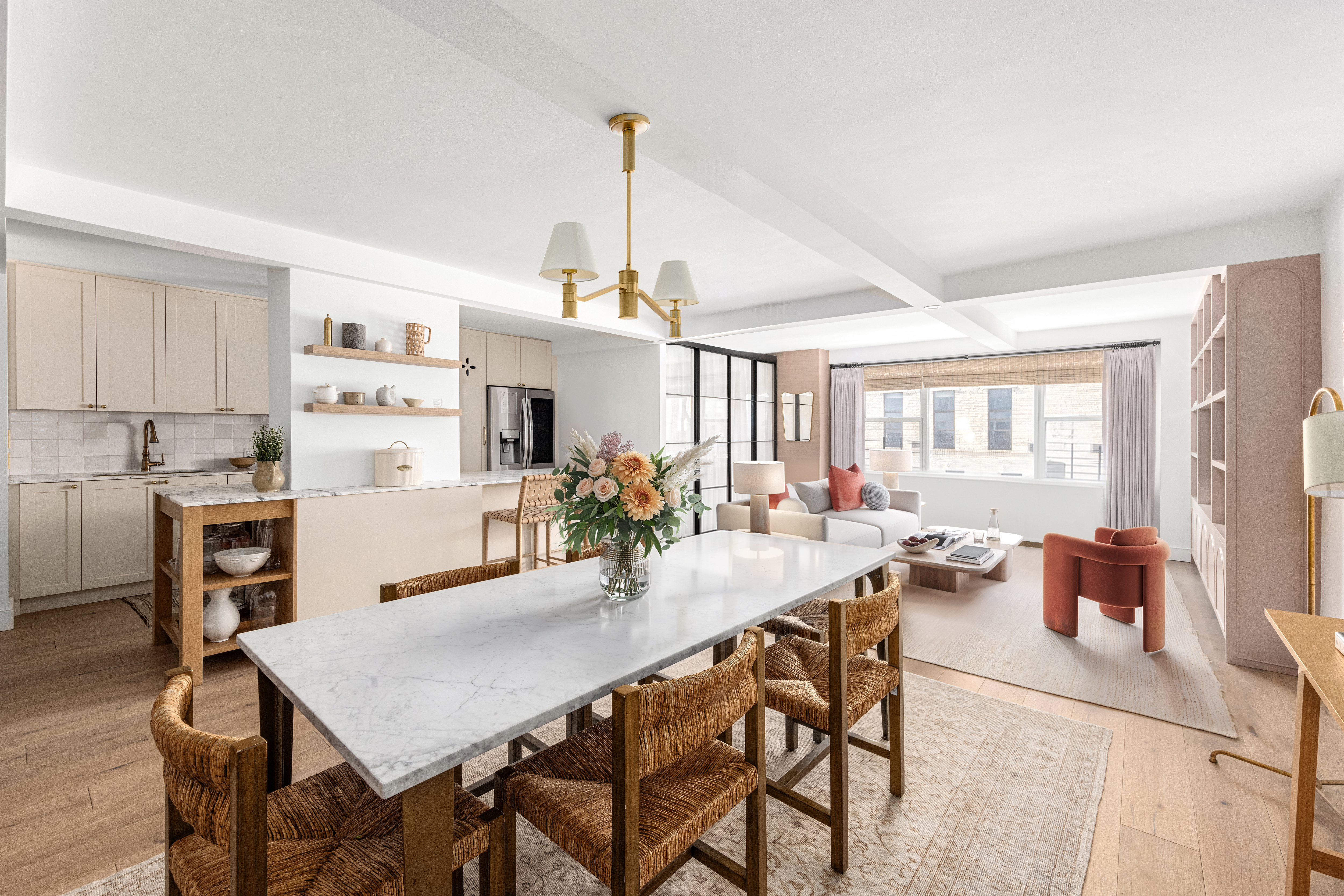 a view of a dining room and livingroom with furniture wooden floor a rug a flat screen tv a rug and a chandelier