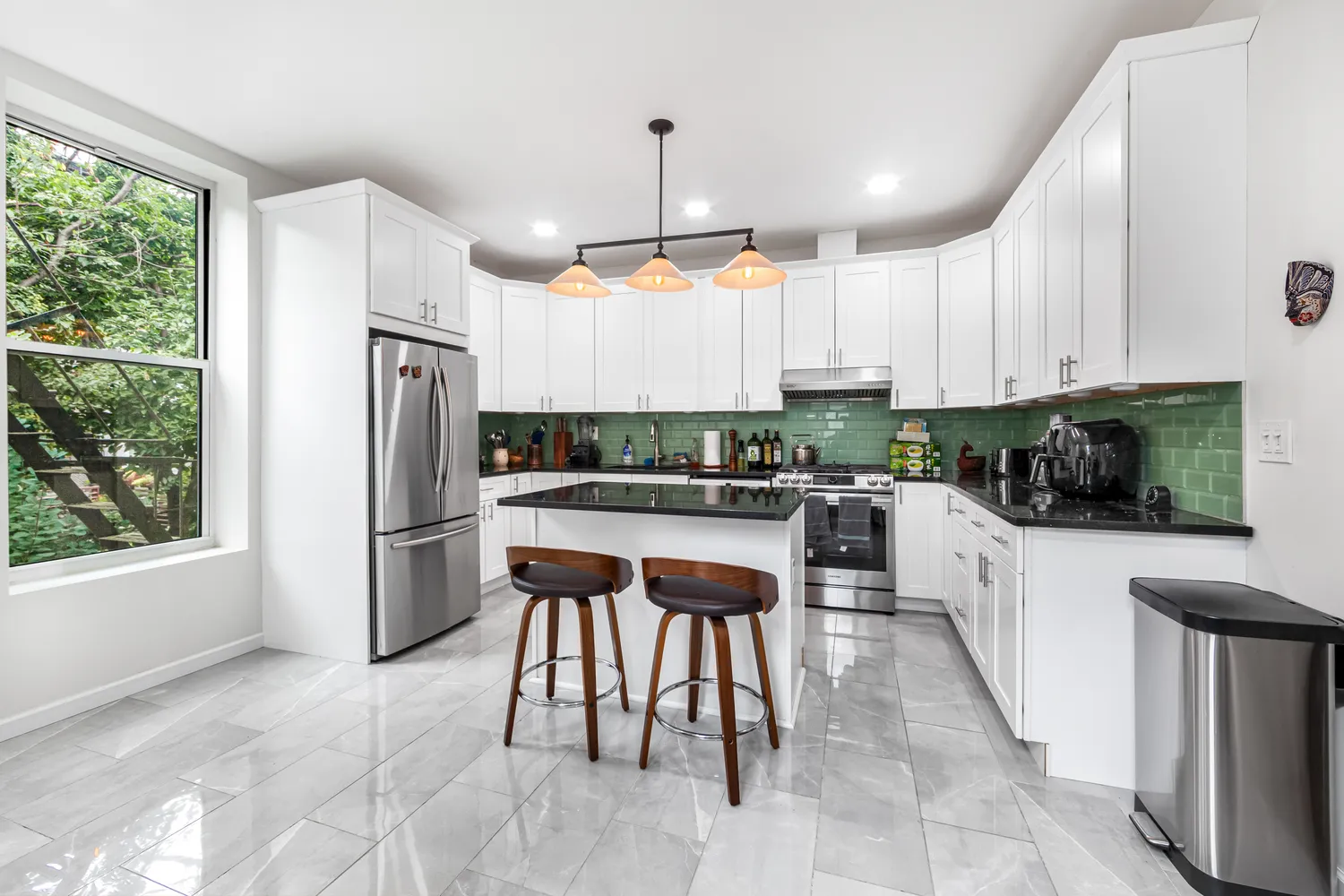 a kitchen with a refrigerator a microwave a stove and white cabinets with wooden floor