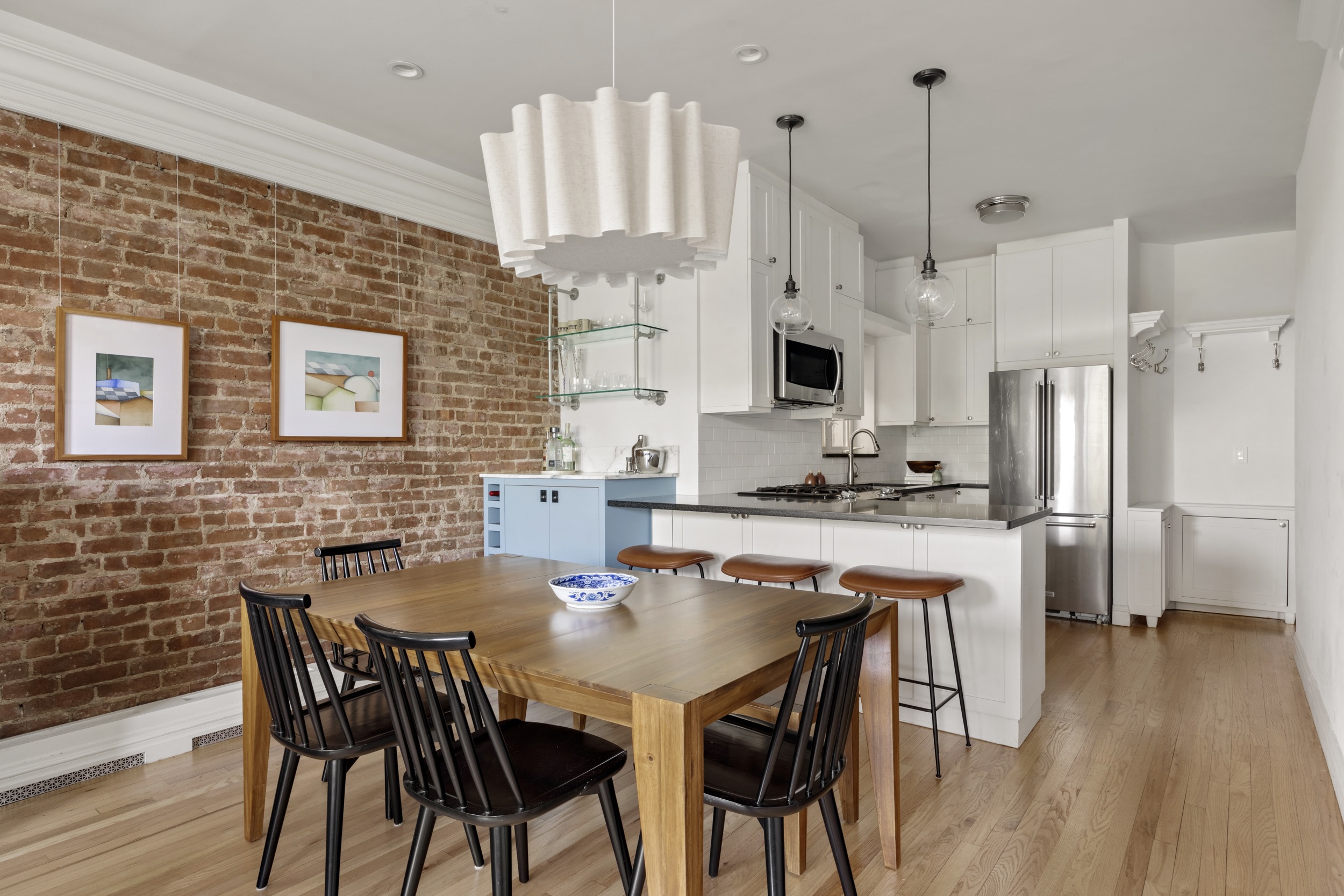 209 Clinton Street, Unit 4L Brooklyn, NY 11201 - Photo 6 of 17 a kitchen with stainless steel appliances granite countertop a stove a kitchen island a refrigerator a stove a dining table and chairs with wooden floor