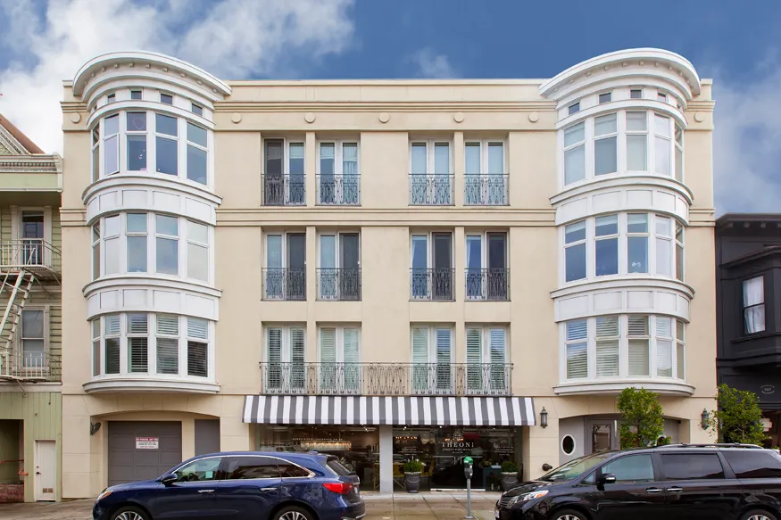 a front view of a residential apartment building with a yard