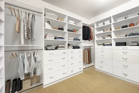 a view of walk in closet with clothes and shoes