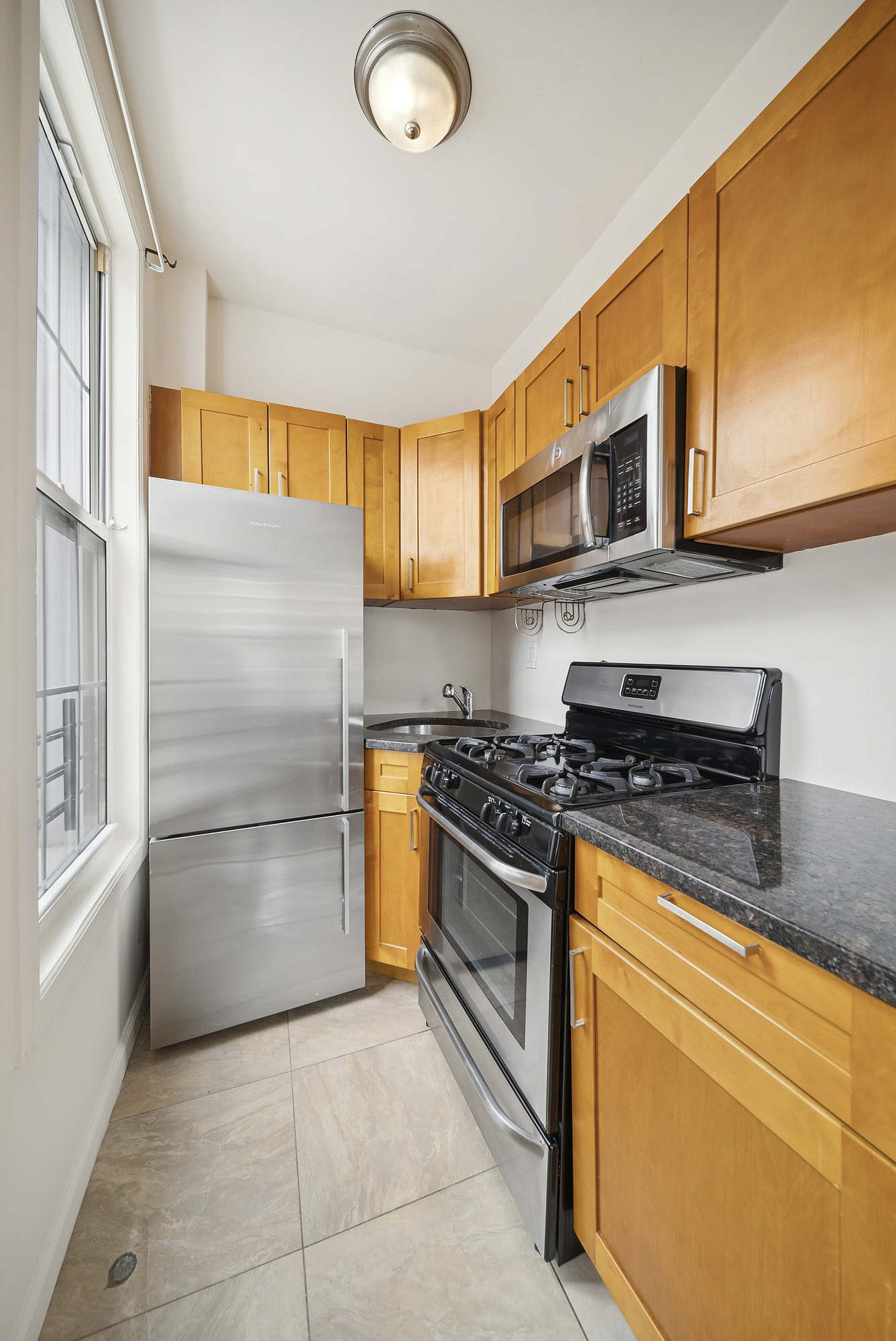 109 Moffat Street, Unit 2F Brooklyn, NY 11207 - Photo 6 of 8 a kitchen with stainless steel appliances granite countertop a stove and a refrigerator
