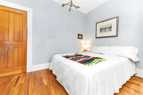 a bedroom with a bed and wooden floor