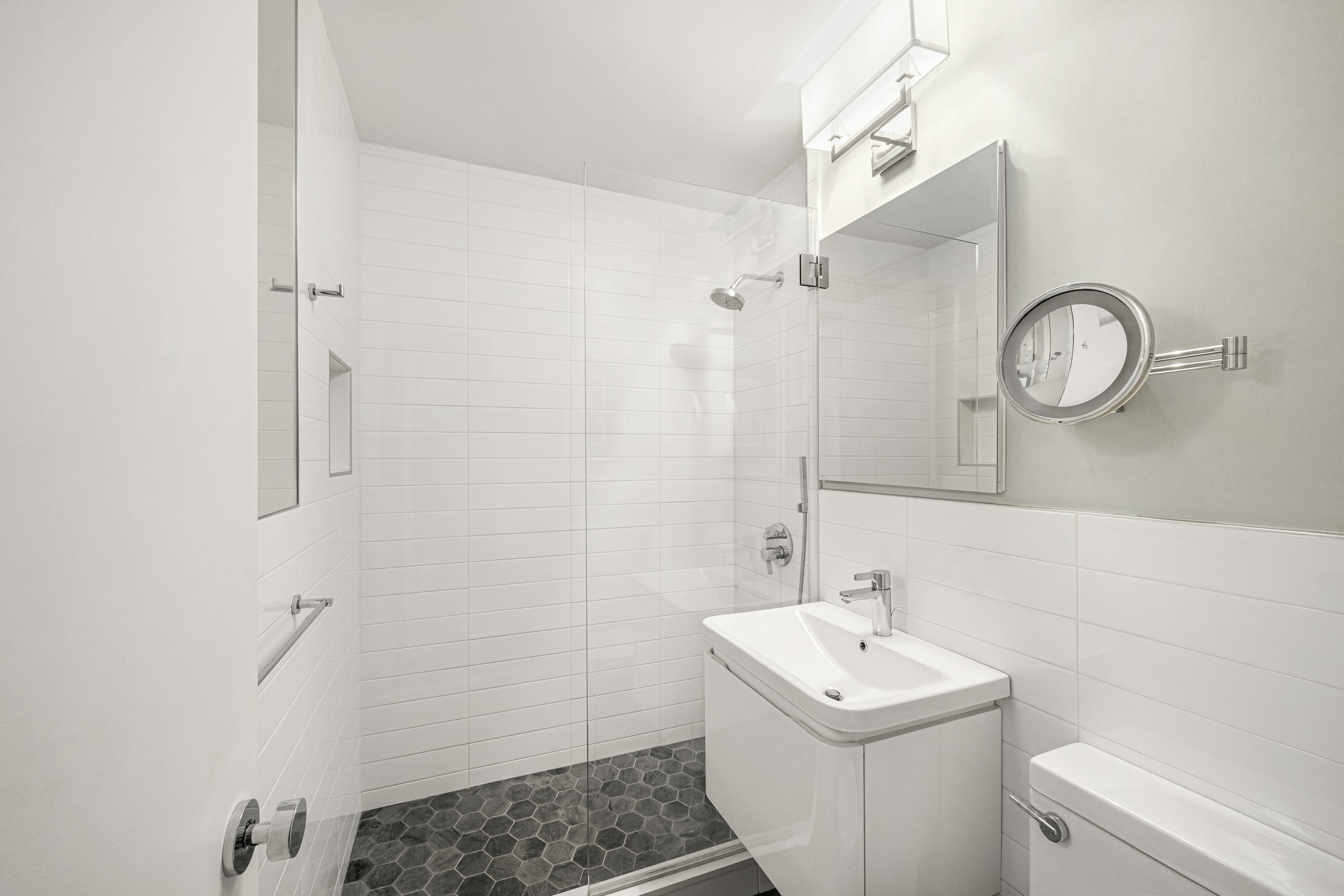 77 West 55th Street, Unit 9F Manhattan, NY 10019 - Photo 10 of 11 a bathroom with a sink a toilet and a mirror