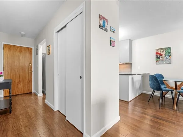 a view of a hallway with wooden floor and furniture