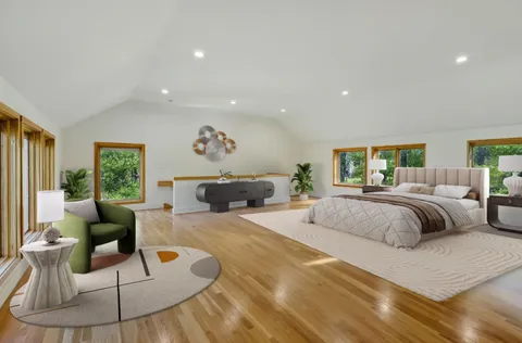 a spacious bedroom with a bed a couch and a large window