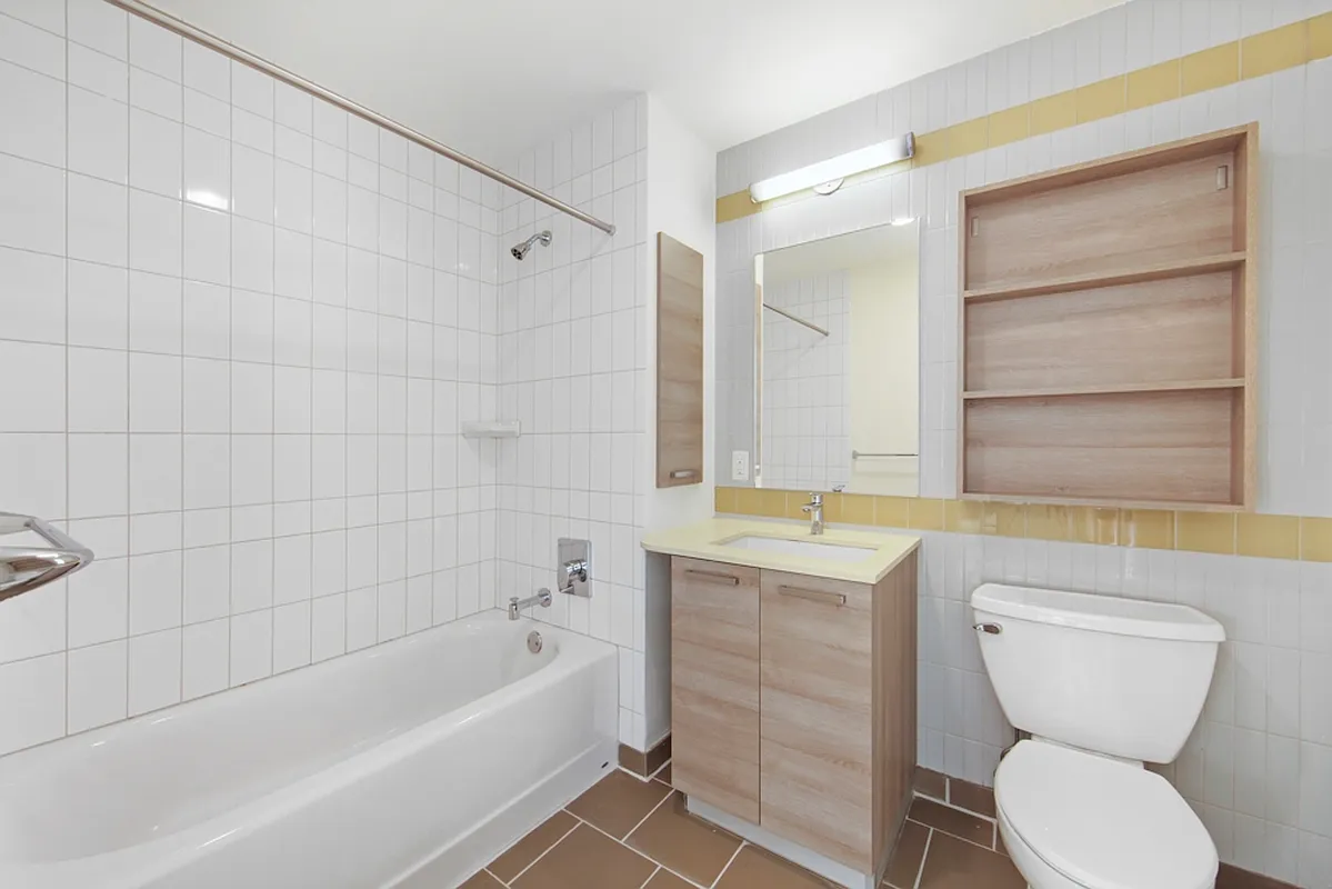 626 Flatbush Avenue, Unit 7E Brooklyn, NY 11225 - Photo 8 of 23 a bathroom with a granite countertop toilet a sink and bathtub