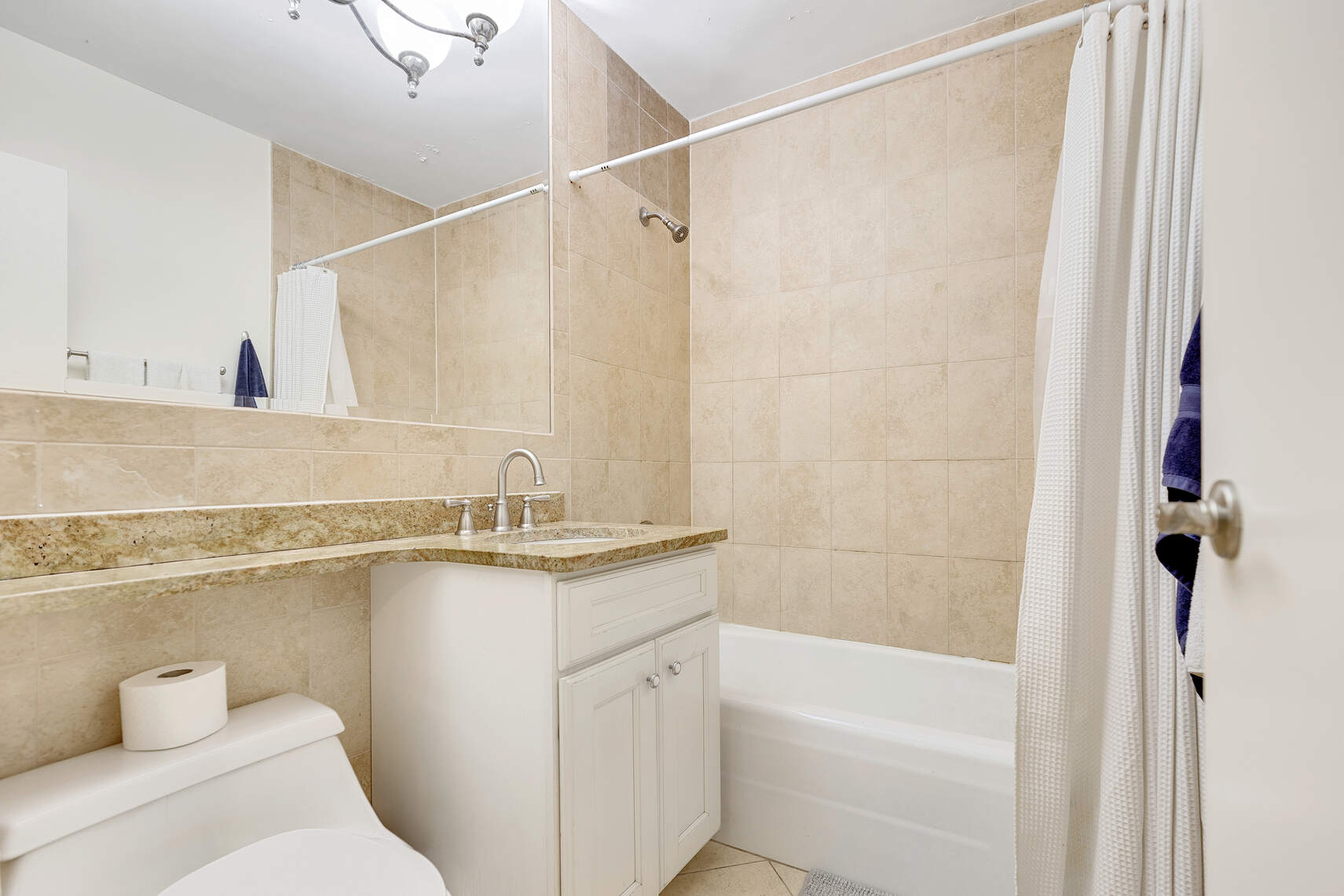 159 West 53rd Street, Unit 18B Manhattan, NY 10019 - Photo 6 of 11 a bathroom with a granite countertop sink a toilet and shower