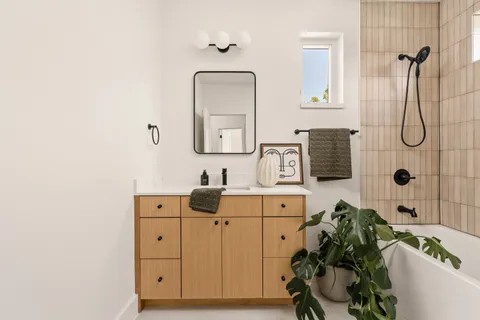 a bathroom with a bathtub sink and mirror