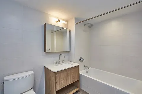 a bathroom with a bathtub a sink a toilet and a mirror