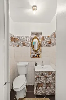 a bathroom with a toilet sink and mirror