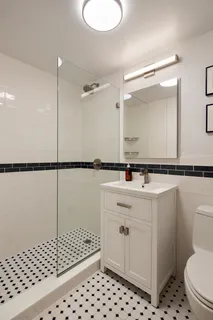 a bathroom with a sink a toilet a mirror and shower