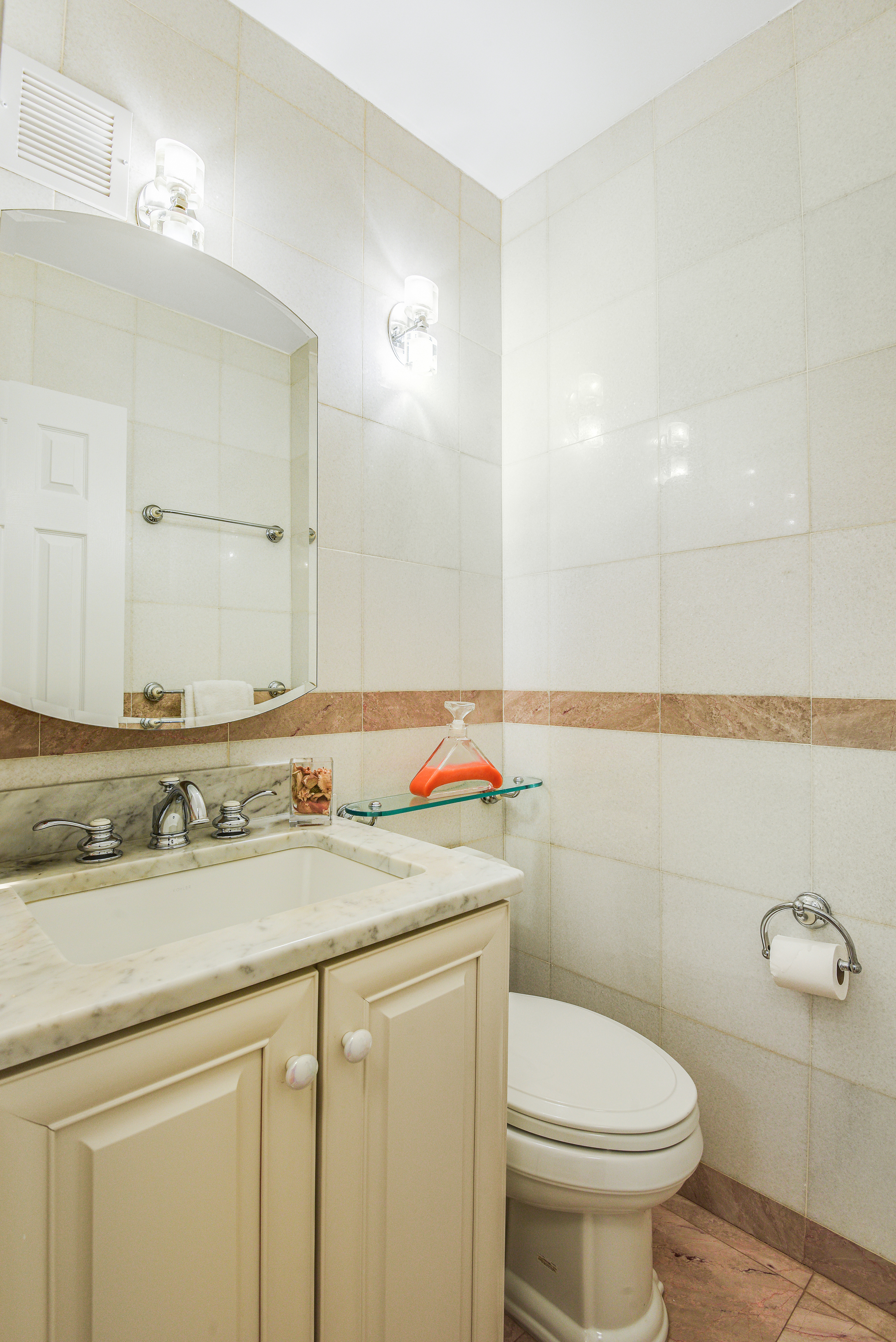 200 Central Park South, Unit 5M Manhattan, NY 10019 - Photo 11 of 15 a bathroom with a sink toilet vanity and mirror