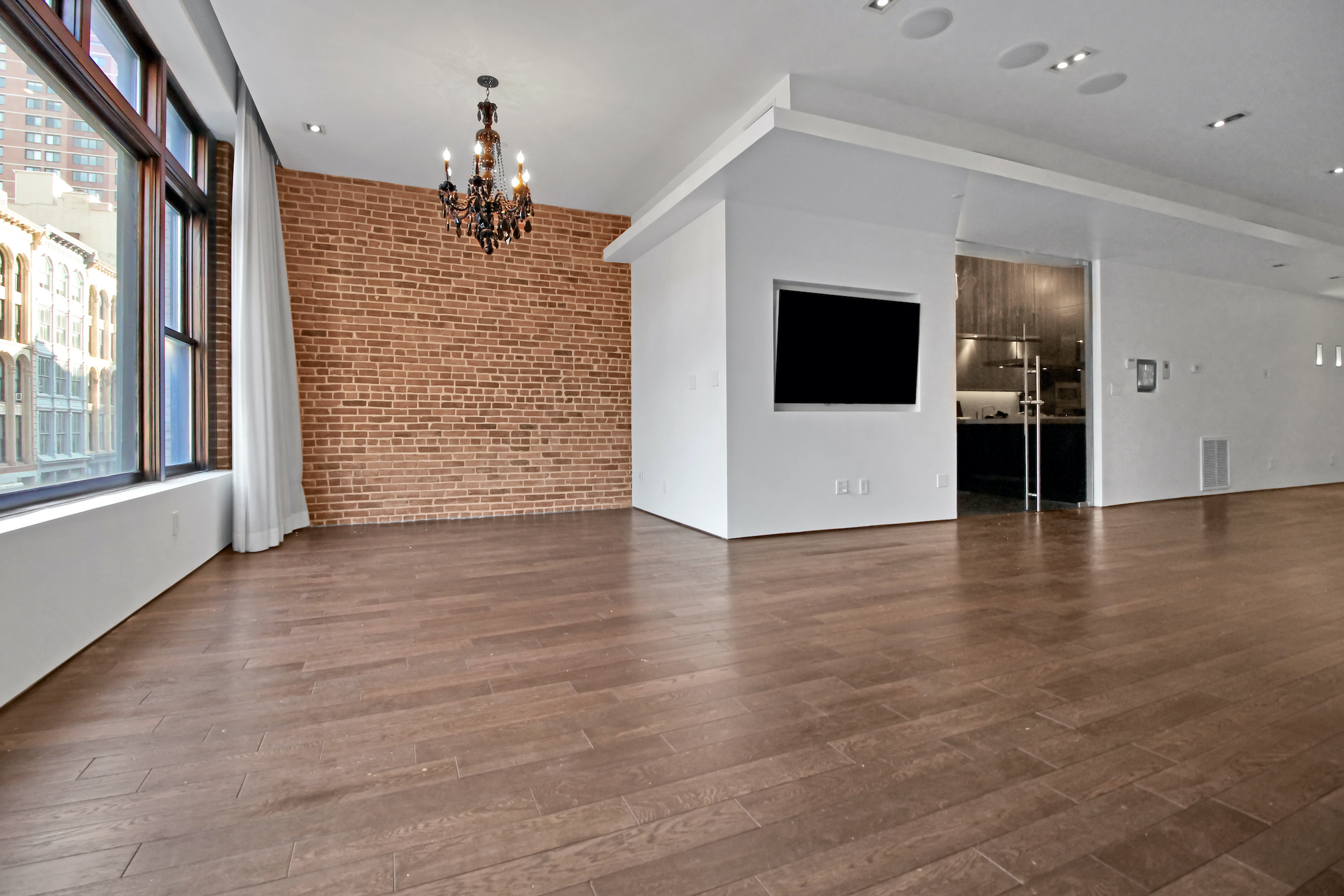 405 Broadway, Unit 3 Manhattan, NY 10013 - Photo 4 of 11 a view of a livingroom with wooden floor and a ceiling fan