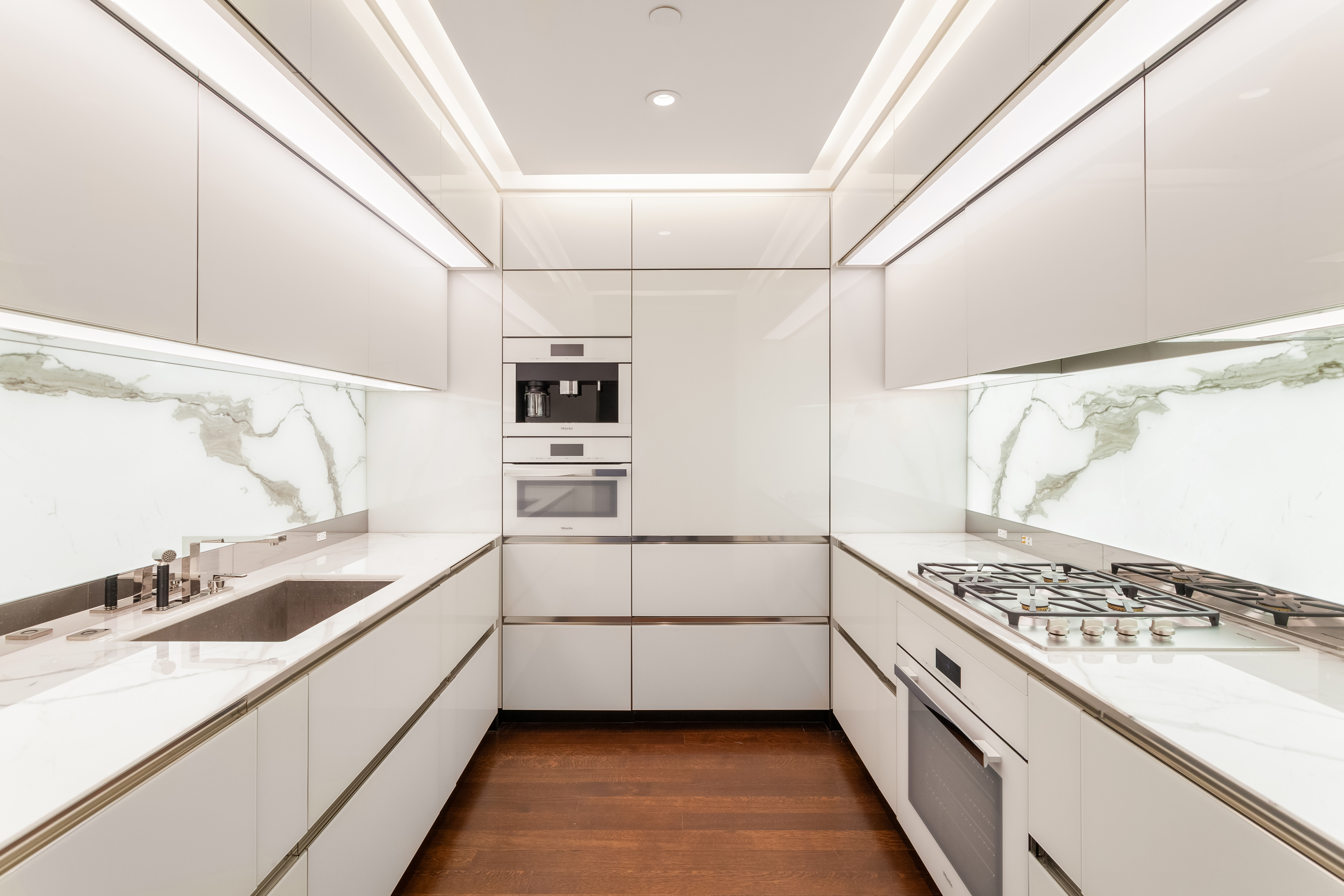 53 West 53rd Street, Unit 16C Manhattan, NY 10019 - Photo 7 of 12 a kitchen with stainless steel appliances kitchen island granite countertop a sink and cabinets
