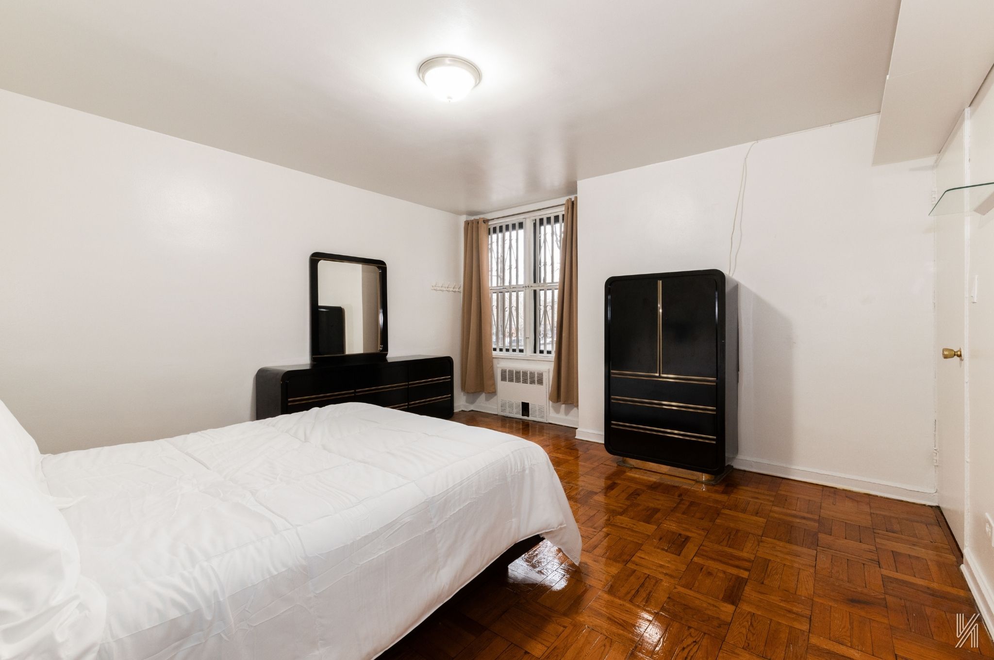 33-24 Junction Boulevard, Unit 1R Queens, NY 11372 - Photo 12 of 17 a bedroom with a bed and dresser with mirror
