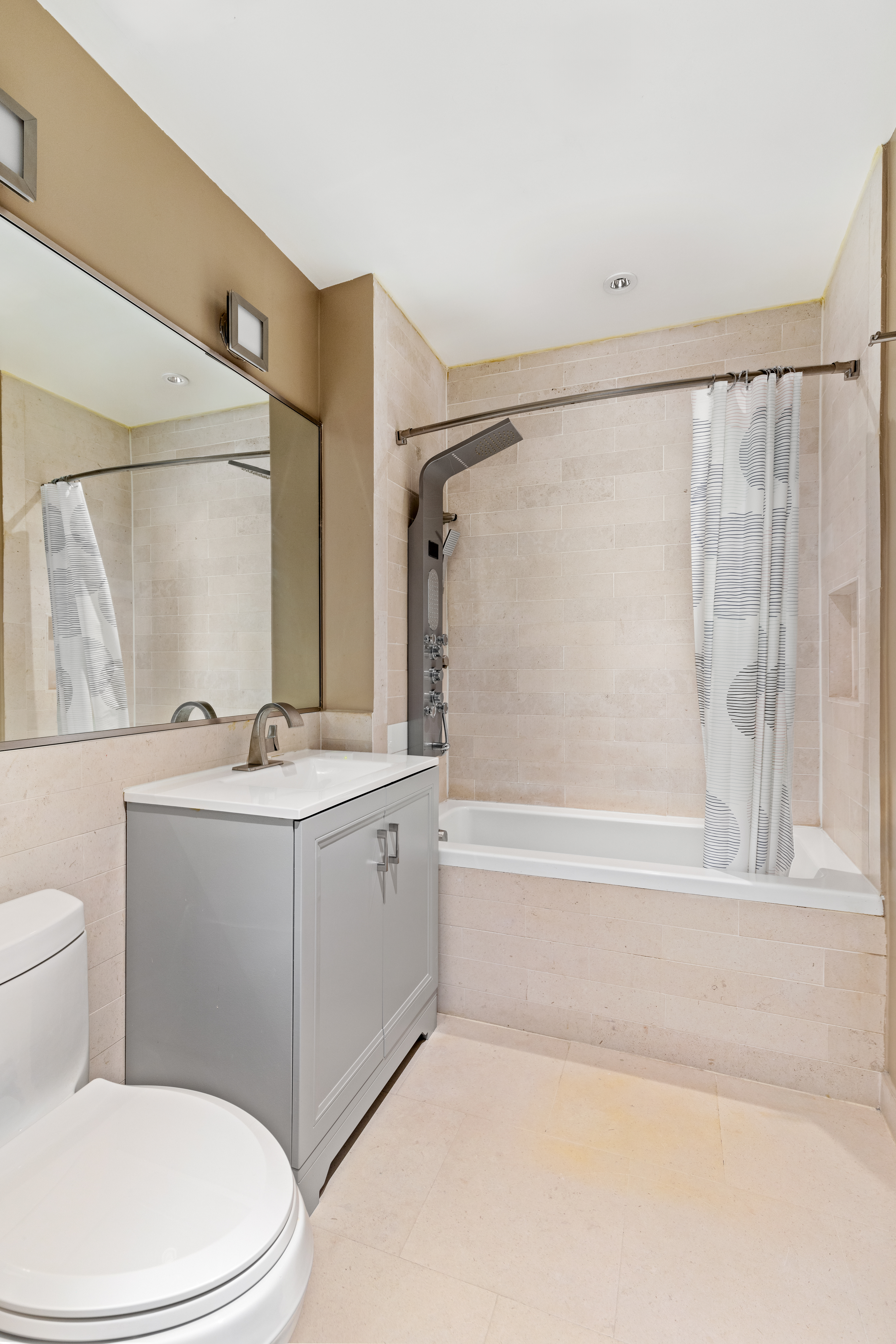 212 East 95th Street, Unit 2C Manhattan, NY 10128 - Photo 10 of 11 a bathroom with a granite countertop sink toilet and shower